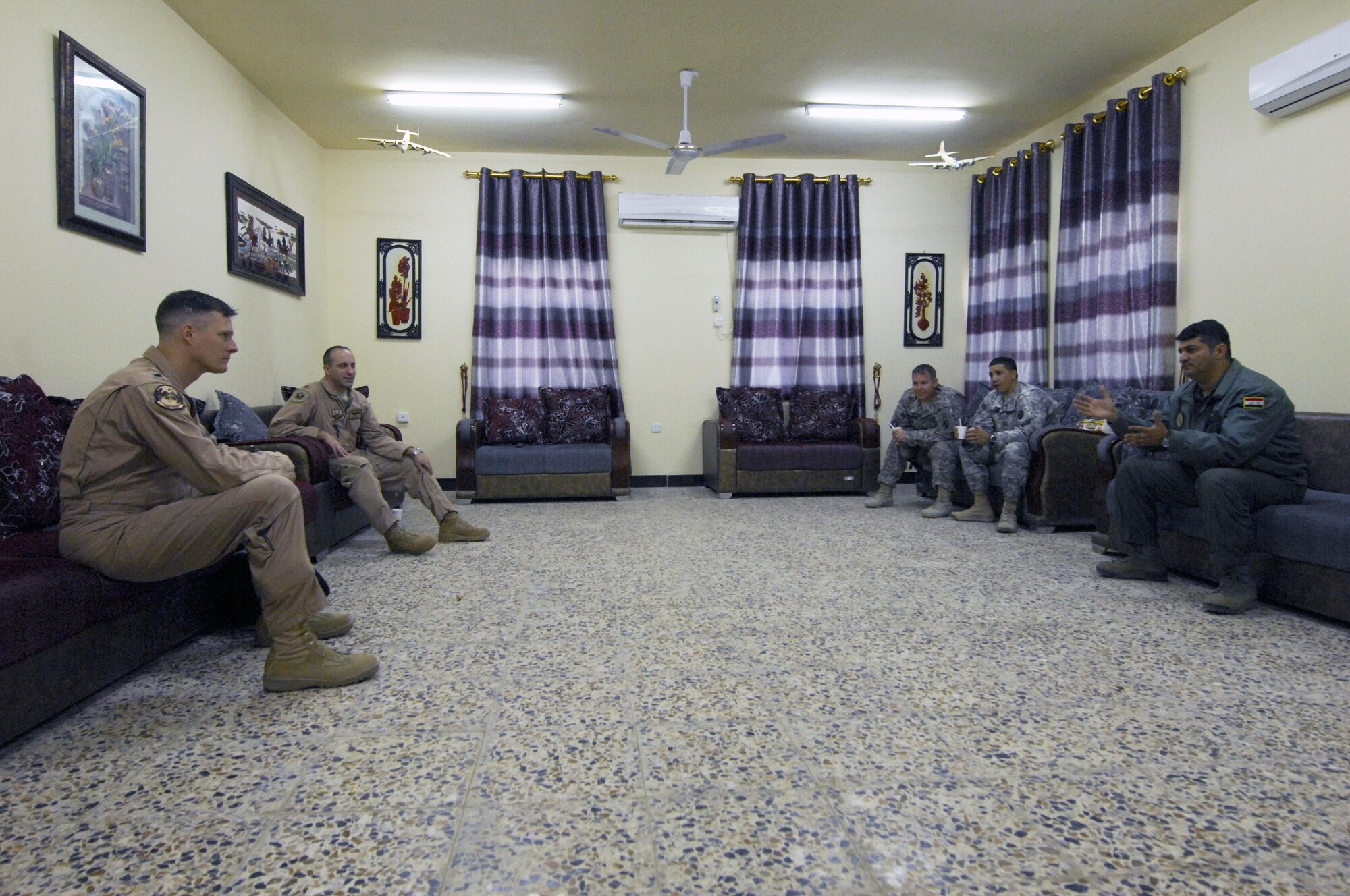 Airmen and soldiers from the advise and assist team talk with Iraqi air force pilot Lt. Col. Thaer of the 23rd Squadron about the Iraqi airdrop capability Jan. 5, 2014. The Iraqi air force has been working with members of the 386th Air Expeditionary Wing and the U.S. Army on developing and improving the airdrop capability of the Iraqi air force. To date, the 23rd Squadron of the Iraqi air force has dropped more than 200 bundles. (U.S. Air Force photo by 1st Lt Sarah Ruckriegle/released)