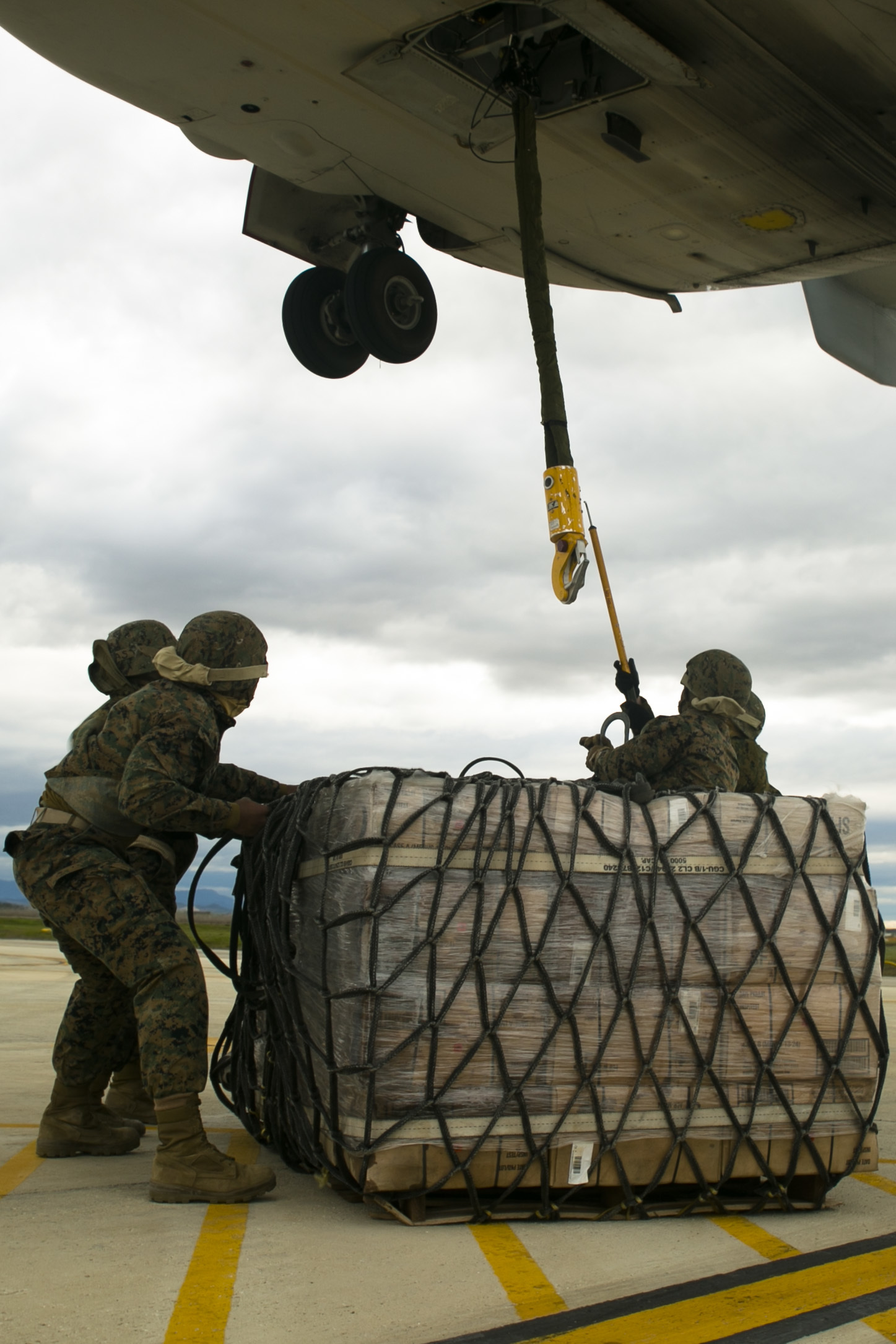 U.S. Marine landing support specialists with Special-Purpose Marine Air-Ground Task Force Crisis Response-Africa attach a pallet of supplies to an MV-22 Osprey during an external lift drill at Morón Air Base, Spain, Jan. 19, 2015. The Marines used a grounding cable to counter the static-electric charge generated by the Osprey before attaching a 2180-pound pallet to complete the lift. (U.S. Marine Corps photo by Sgt. Paul Peterson)
