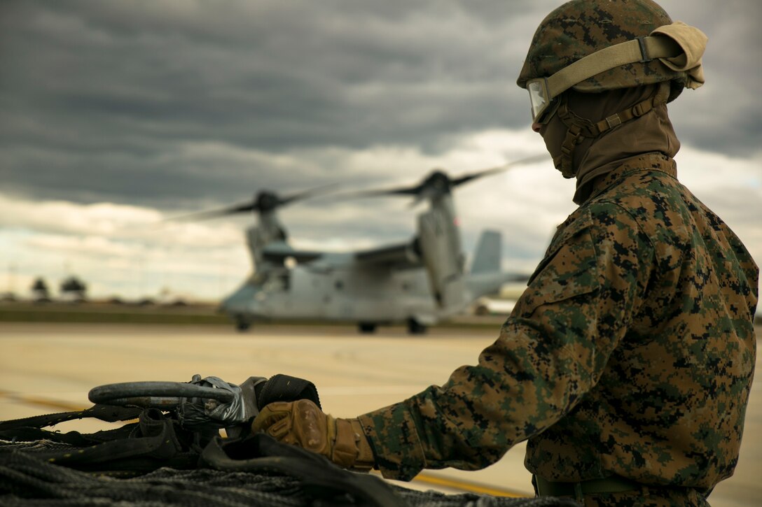 U.S. Marine Lance Cpl. Cody Keller, a landing support specialist with Special-Purpose Marine Air-Ground Task Force Crisis Response-Africa, stands on the flight line at Morón Air Base, Spain, during an external-lift drill with an MV-22 Osprey Jan. 19, 2015. The long-range, vertical-lift capabilities of the Osprey make it a versatile aircraft for supporting transportation missions in places such as Africa.