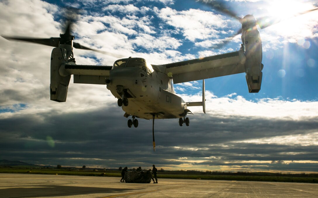 An MV-22 Osprey from Special-Purpose Marine Air-Ground Task Force Crisis Response-Africa hovers over a 2180-pound pallet during an external-lift drill at Morón Air Base, Spain, Jan. 19, 2015. The hurricane-like winds from the aircraft blasted Marines on the ground as they connected the pallet to the Osprey’s lift cable. (U.S. Marine Corps photo by Sgt. Paul Peterson)
