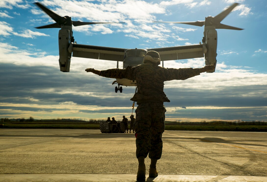 U.S. Marine Lance Cpl. Cody Keller, a landing support specialist with Special-Purpose Marine Air-Ground Task Force Crisis Response-Africa, signals an MV-22 Osprey to level out over a pallet of supplies during an external-lift drill at Morón Air Base, Spain, Jan. 19, 2015. Pilots in the Osprey used Keller’s signals to gage their movements over the obscured pallet of supplies beneath them. (U.S. Marine Corps photo by Sgt. Paul Peterson)