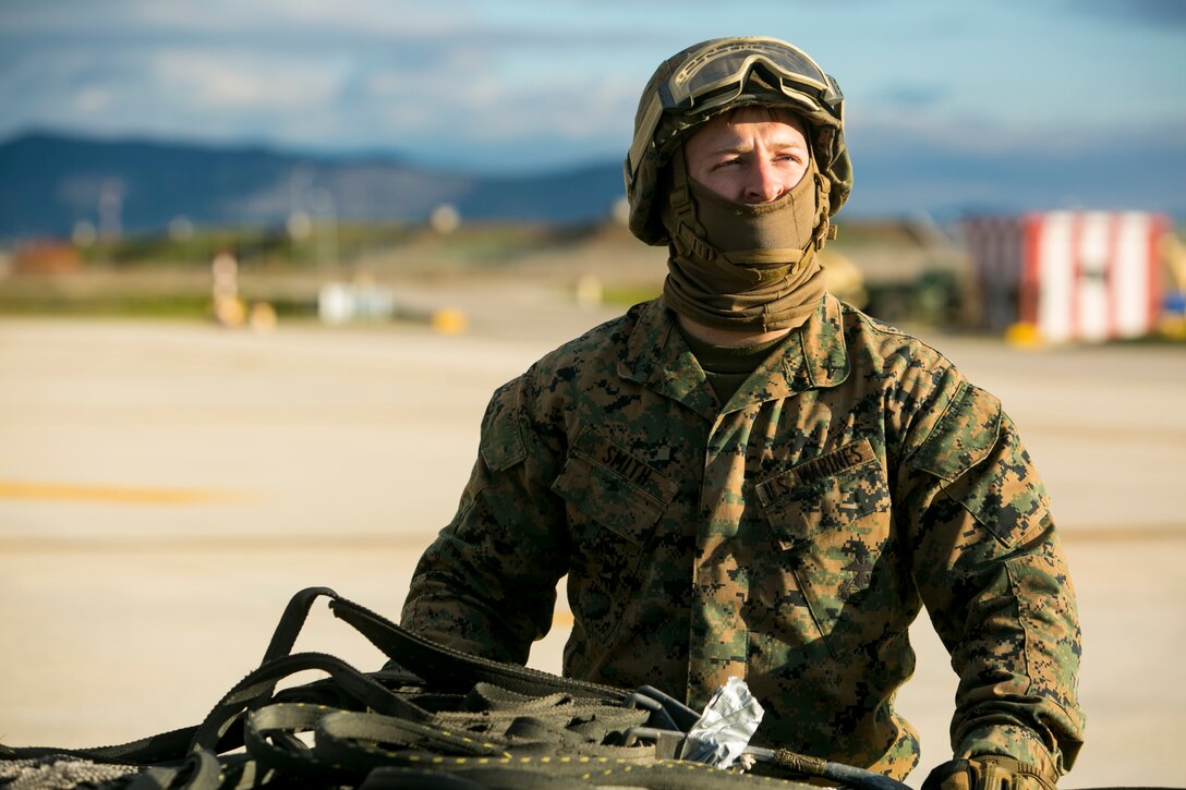 Lance Cpl. Derek Smith, a landing support specialist with Special-Purpose Marine Air-Ground Task Force Crisis Response-Africa, stands on the flight line at Morón Air Base, Spain, during an external-lift drill with the MV-22 Osprey Jan. 19, 2015. Smith worked with a team of landing support specialists to connect a 2180-pound pallet to the lift-cable of an Osprey. (U.S. Marine Corps photo by Sgt. Paul Peterson)