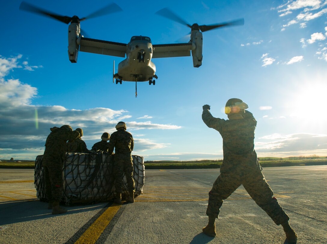 Cpl. Nashion Crutchfieldward, a Marine with Special-Purpose Marine Air-Ground Task Force Crisis Response-Africa, signals an MV-22 Osprey during an external-lift drill at Morón Air Base, Spain, Jan. 19, 2015. Crutchfieldward fought against the powerful downwash of the Osprey to provide hand and arm signals to the pilots as they hovered to pick up a load of supplies. (U.S. Marine Corps photo by Sgt. Paul Peterson)