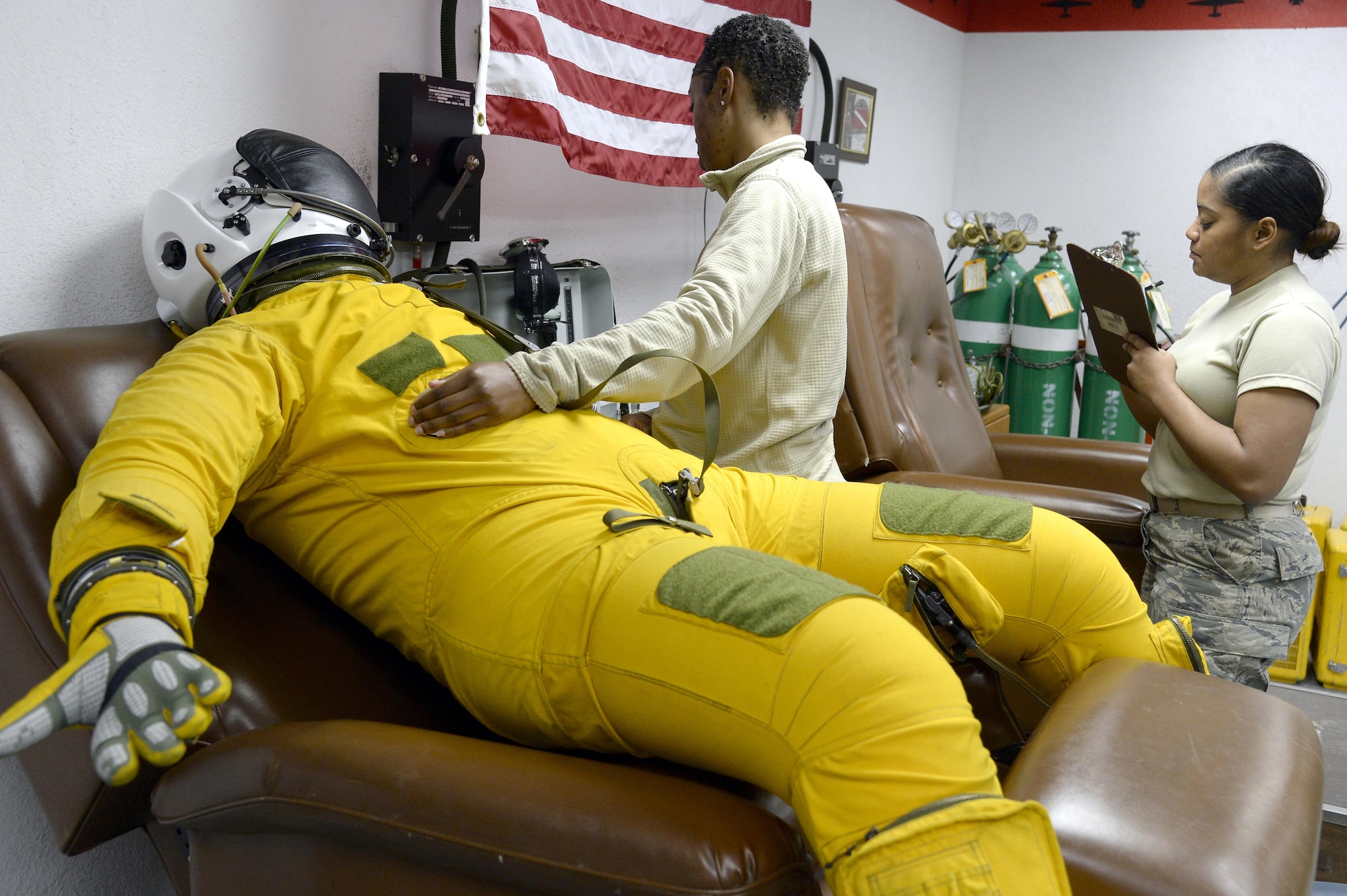 Senior Airmen Andrea, left, and Tamika perform a post-flight inspection on a full pressure suit Jan. 20, 2015, at an undisclosed location in Southwest Asia. Whether it is at 65,000 feet in the air or on the ground, the equipment the physiological support detachment Airmen maintain and inspect will aid the pilots in surviving and evading. The Airmen are launch and recovery technicians (U.S. Air Force photo/Tech. Sgt. Marie Brown)