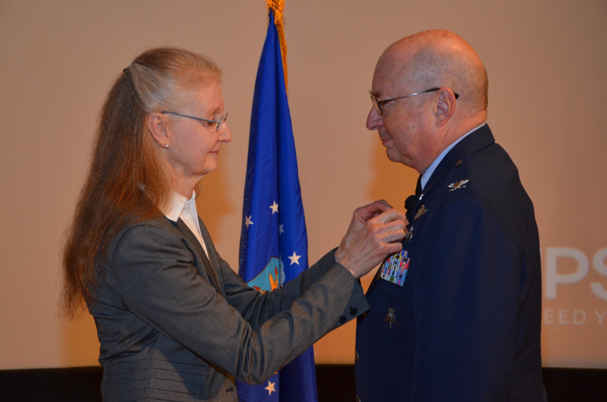 Col. (Dr.) Lewis Neace receives his official retirement pin from his wife at his retirement ceremony at Patrick Air Force Base Jan. 11, 2015. Neace completed more than 31 years of service as an Air Force Reserve physician and was most recently the commander of the 920th Aeromedical Staging Squadron at Patrick. (U.S. Air Force photo/2nd Lt. Anna-Marie Wyant) 
