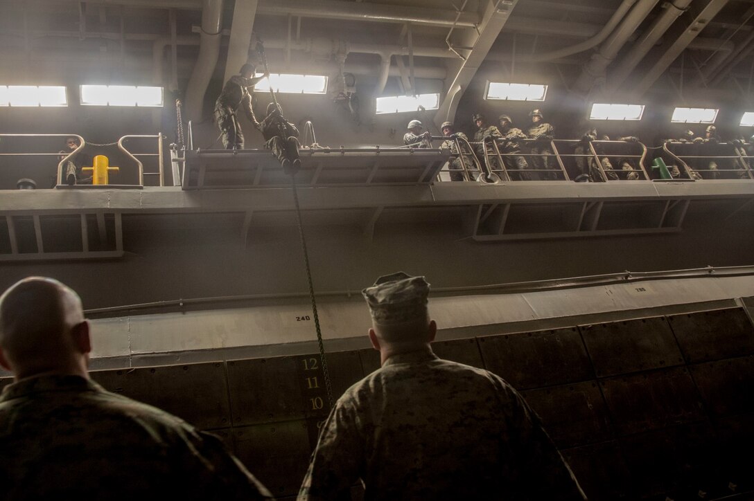 U.S. Marines with the 15th Marine Expeditionary Unit's Maritime Raid Force practice fast-roping procedures in the well deck of USS Essex (LHD 2) at Naval Base San Diego Jan. 24, 2015. The 15th MEU was embarked aboard the three ships of the Essex Amphibious Ready Group - the USS Essex, USS Anchorage (LPD 23), and USS Rushmore (LSD 47) – to familiarize themselves with the ships as they continue to prepare for their upcoming deployment this spring. (U.S. Marine Corps photo by Cpl. Elize McKelvey/Released)