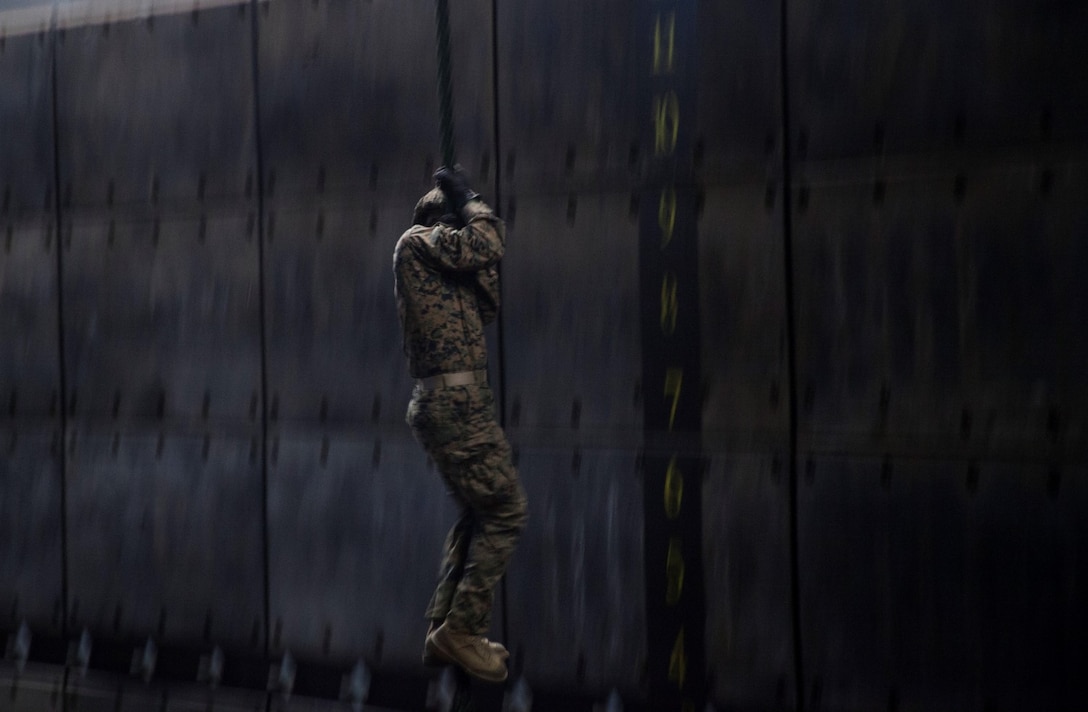 A U.S. Marine with the 15th Marine Expeditionary Unit's Maritime Raid Force practices fast-roping procedures in the well deck of USS Essex (LHD 2) at Naval Base San Diego Jan. 24, 2015. The 15th MEU was embarked aboard the three ships of the Essex Amphibious Ready Group - the USS Essex, USS Anchorage (LPD 23), and USS Rushmore (LSD 47) – to familiarize themselves with the ships as they continue to prepare for their upcoming deployment this spring. (U.S. Marine Corps photo by Cpl. Elize McKelvey/Released)