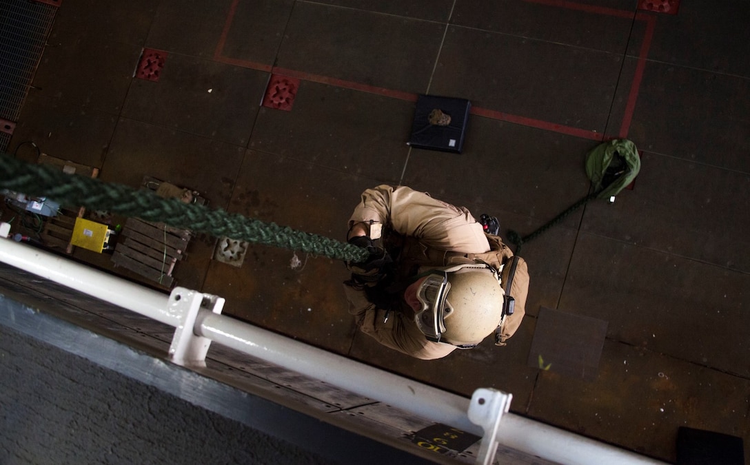 A U.S. Marine with the 15th Marine Expeditionary Unit’s Maritime Raid Force practice fast-roping procedures in the well deck of USS Essex (LHD 2) at Naval Base San Diego Jan. 24, 2015. The 15th MEU was embarked aboard the three ships of the Essex Amphibious Ready Group - the USS Essex, USS Anchorage (LPD 23), and USS Rushmore (LSD 47) – to familiarize themselves with the ships as they continue to prepare for their upcoming deployment this spring. (U.S. Marine Corps photo by Cpl. Elize McKelvey/Released)