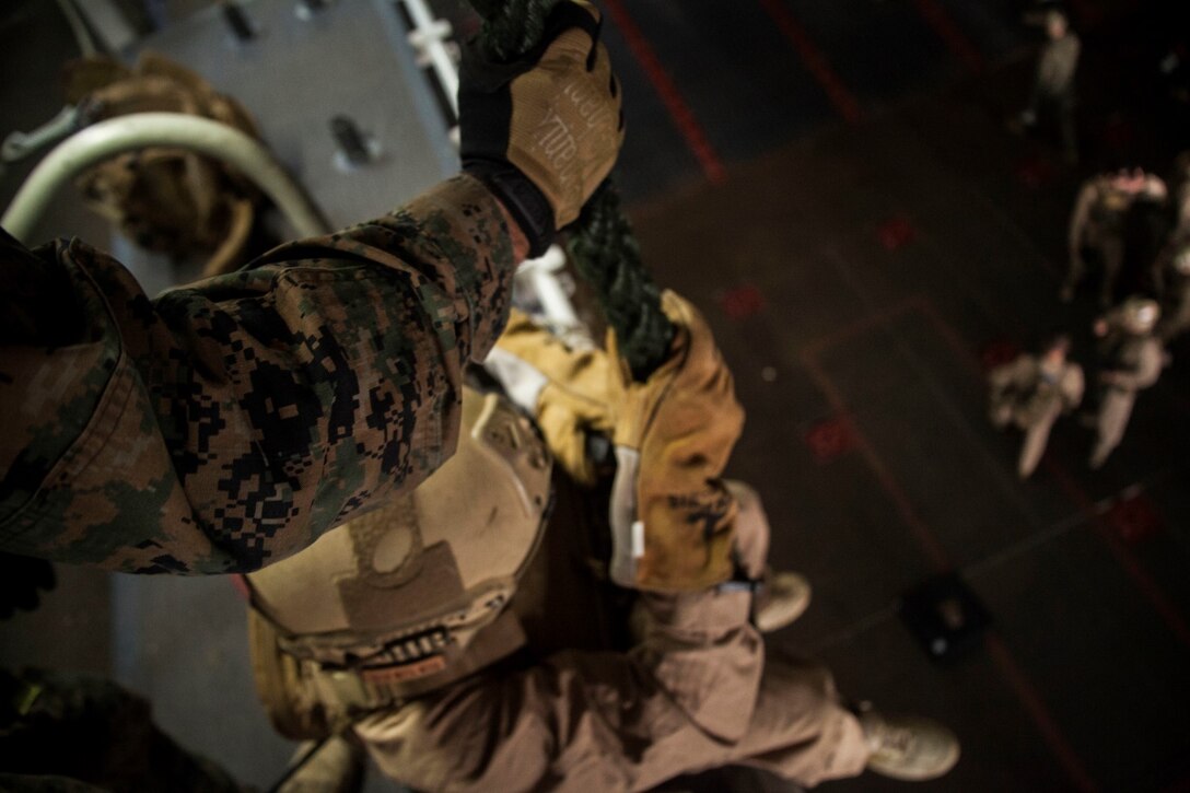 U.S. Marines with the 15th Marine Expeditionary Unit's Maritime Raid Force practice fast-roping procedures in the well deck of USS Essex (LHD 2) at Naval Base San Diego Jan. 24, 2015. The 15th MEU was embarked aboard the three ships of the Essex Amphibious Ready Group - the USS Essex, USS Anchorage (LPD 23), and USS Rushmore (LSD 47) – to familiarize themselves with the ships as they continue to prepare for their upcoming deployment this spring. (U.S. Marine Corps photo by Cpl. Elize McKelvey/Released)