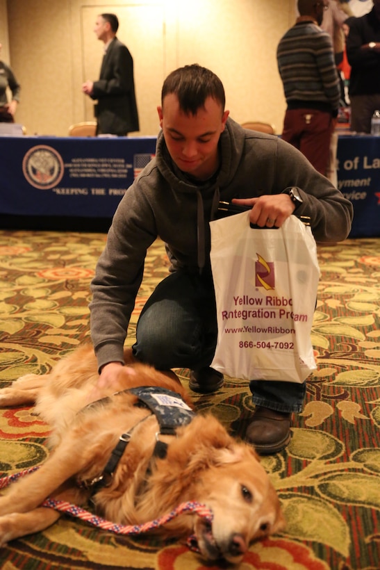 Sgt. William Turner, a team leader, with Personnel Retrieval and Processing Company (-), 4th Marine Logistics Group, pets Valerie, a service dog from the Warrior Canine Connection, at the Yellow Ribbon Re-Integration Program Post-deployment training , Jan. 24-25, 2015 in Washington, D.C. After being deployed to Camp Bastion and Kandahar, Afghanistan, the unit attended the training as a required follow-up to their return to the continental United States. The training featured resources from the Department of Veterans Affairs, the American Red Cross, Employer Support of the Guard and Reserve, Marine For Life, and other organizations which offer financial, medical and employment advice. (U.S. Marine Corps photo by Cpl. Tiffany Edwards)