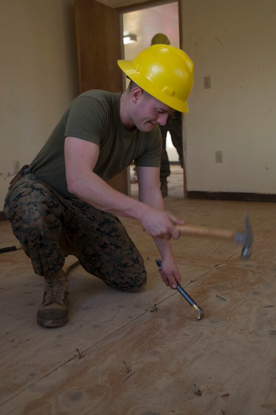 Cpl. Joseph Dutton, from Brookline, Vermont, pries nails loose in the wooden flooring in an old military housing facility, Jan. 9, 2015, during exercise Lava Viper 15-1.2. at Kawaihae Harbor, Hawaii. The housing facility is used by various military branches as a safe house while waiting for ships to arrive with vehicles and supplies. Combat engineers with Marine Wing Support Squadron-472, Marine Aircraft Group 49, 4th Marine Air Wing has been tasked to refurbish the facility because the building is deteriorating. 