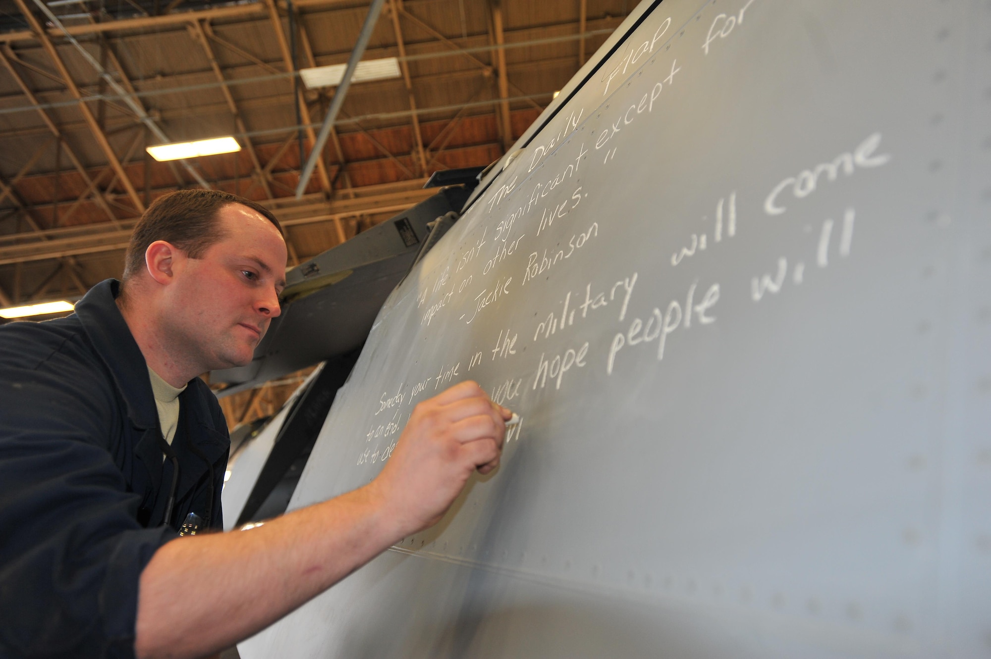 Tech. Sgt. Eric Laflin writes an inspirational quote, referred to as the “daily flap,” on an aircraft’s wing inboard flap Jan. 10, 2015, at Fairchild Air Force Base, Wash. Laflin began the daily flap roughly six months ago after completing the NCO professional enhancement course here to motivate and inspire Airmen in his shop. Laflin is a 141st Maintenance Squadron aircraft inspector. (U.S. Air Force photo/Staff Sgt. Veronica Montes)