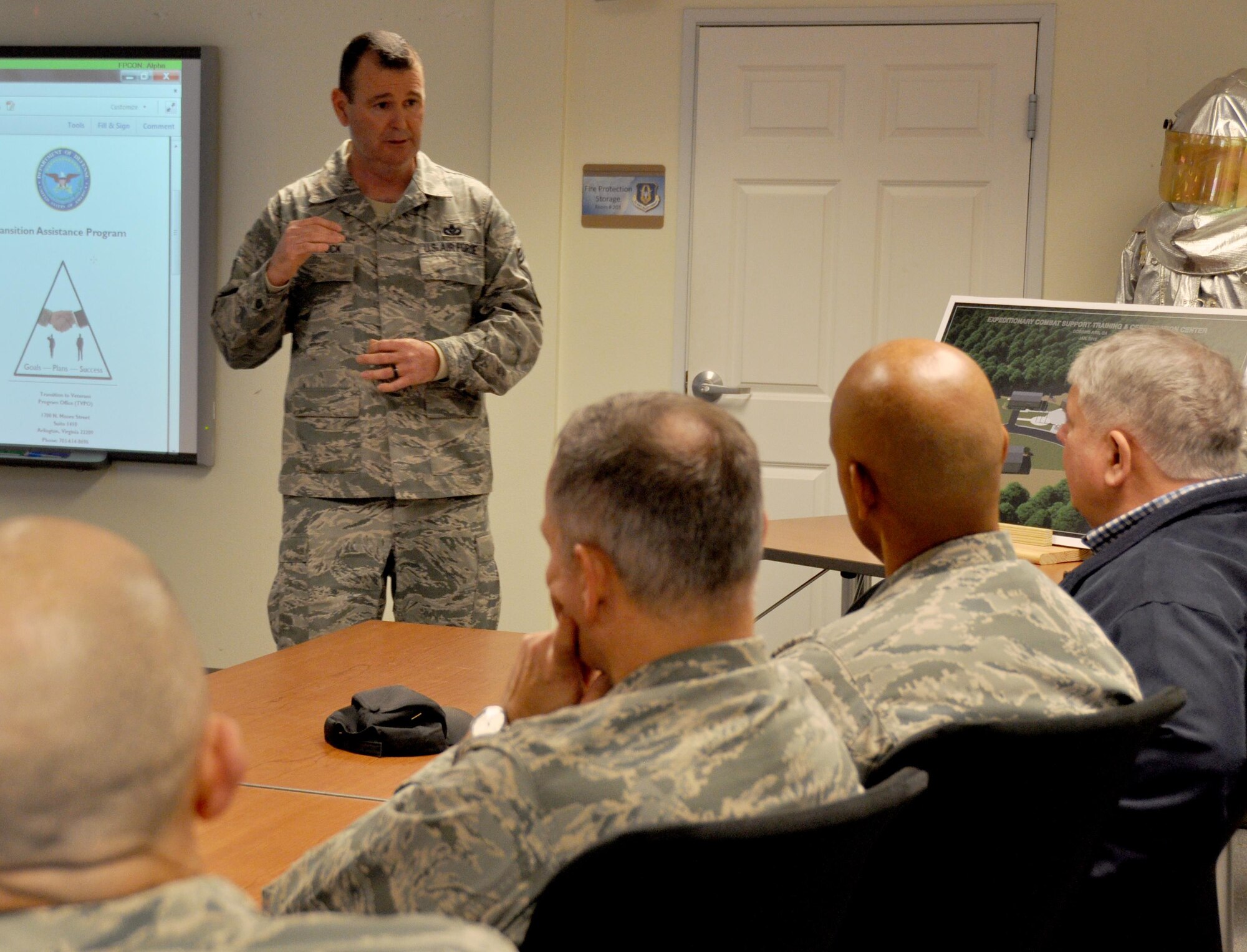 Chief Master Sgt. Trevor Shattuck, Air Force Civil Engineer Center Reserve Career Field Manager, speak with guests at the military and industry tractor trailer training program capstone event at Dobbins Air Reserve Base, Ga. Jan. 23, 2015. Students who go through the course at Dobbins receive certification from the Professional Truck Drivers Institute. (U.S. Air Force photo/Senior Airman Daniel Phelps)