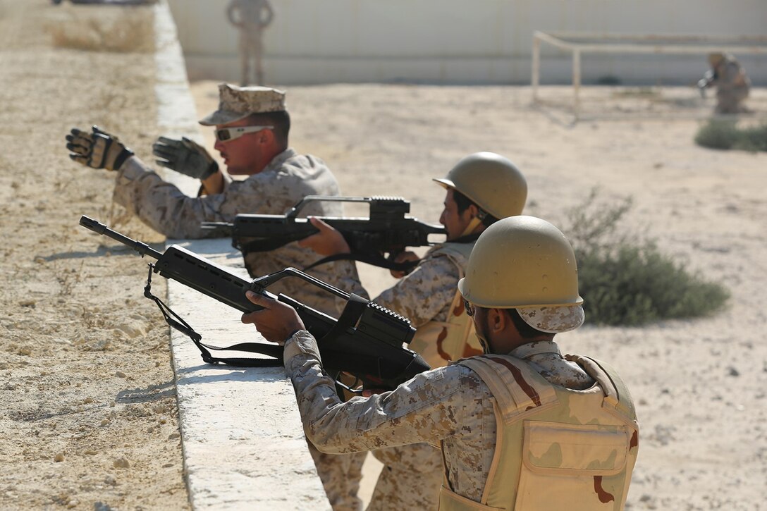 U.S. Marine Corps Lance Cpl. Nicholas Hines, a rifleman with Echo Company, Battalion Landing Team 2nd Battalion, 1st Marines, 11th Marine Expeditionary Unit (MEU), from Ewen, Mich., guides members of the 3rd Saudi Marine Battalion during a live-fire obstacle course as part of exercise Red Reef 15 in the U.S. 5th Fleet area of responsibility, Dec. 12, 2014.  Red Reef, is part of a routine theater security cooperation engagement plan between the U.S. Navy, U.S. Marine Corps and Royal Saudi Naval Forces that serves as an excellent opportunity to strengthen tactical proficiency in critical mission areas and support long-term regional security. (U.S. Marine Corps photo by Sgt. Melissa Wenger/Released)
