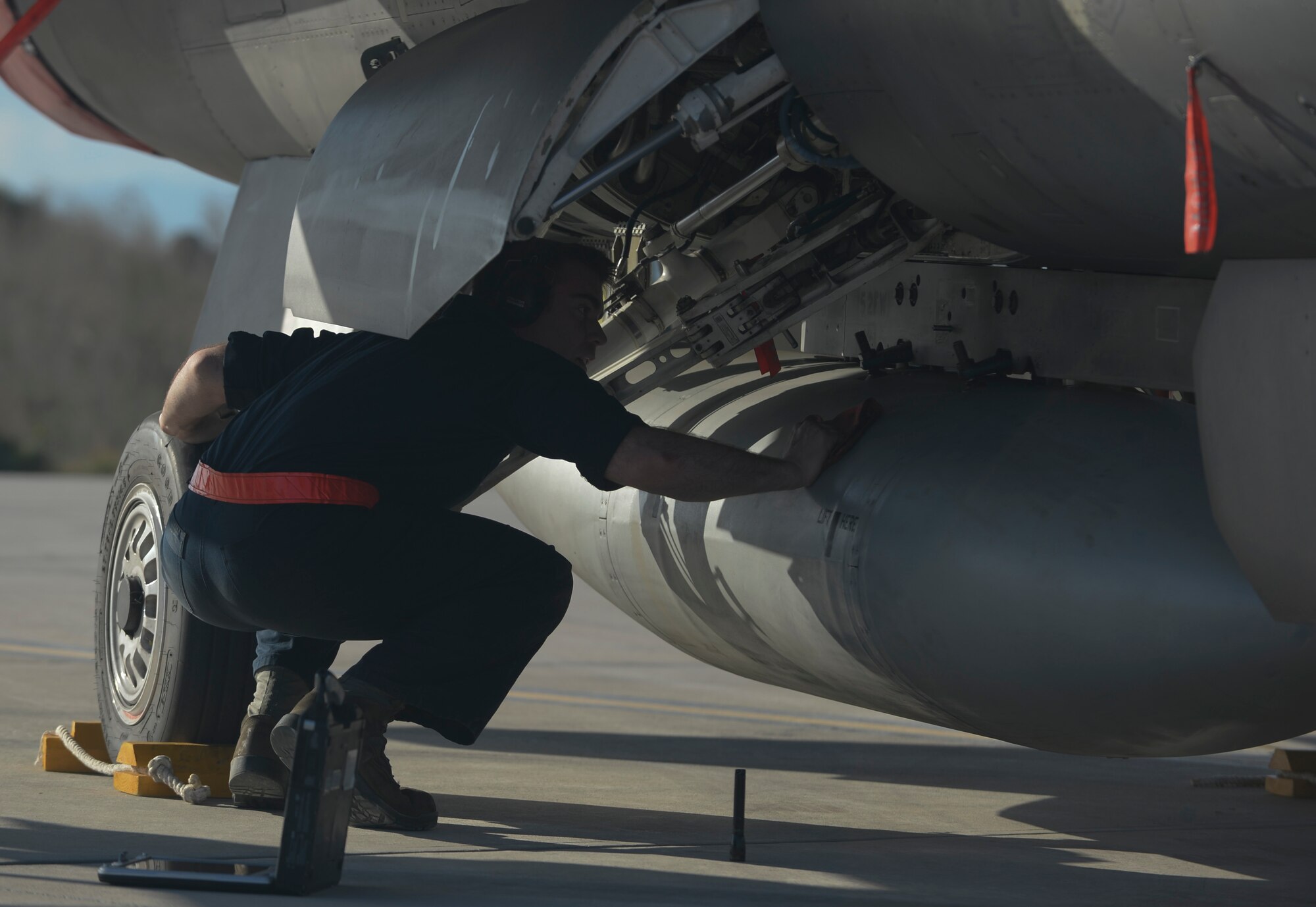 A U.S. Air Force dedicated crew chief assigned to the 52nd Expeditionary Aircraft Maintenance Squadron inspects the underside of a U.S. Air Force F-16 Fighting Falcon fighter aircraft from the 480th Expeditionary Fighter Squadron during a flying training deployment on the flightline at Souda Bay, Greece, Jan. 26, 2015. Approximately 300 personnel and 18 F-16s from the 52nd Fighter Wing at Spangdahlem Air Base, Germany, will support flight during the FTD as part of U.S. Air Forces in Europe-Air Forces Africa's Forward Ready Now stance. (U.S. Air Force photo by Staff Sgt. Joe W. McFadden/Released)