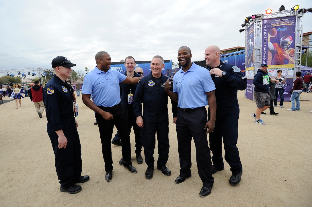 Members of Max Impact, the premier rock band of the U.S. Air Force, speak with Clifford Tubbs, Next League Incorporated Owner, left, and Bethel Johnson, former New England Patriots wide receiver, right, at Fan Fest in Scottsdale Az., Jan. 26, 2015.  The week-long entertainment, food and fashion event is home to Entertainment Sports and Programming Network's live broadcast for Super Bowl XLIX. (U.S. Air Force photo by/ Senior Airman Nesha Humes)
