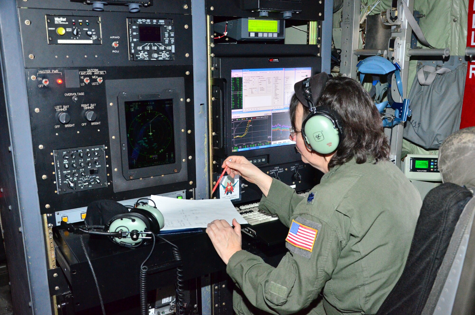 Lt. Col. Valerie Hendry, an aerial reconnaissance weather officer with the 53rd Weather Reconnaissance Squadron checks data during winter storm "Iola" 23 Jan. (U.S. Air Force Photo/Master Sgt. Brian Lamar)