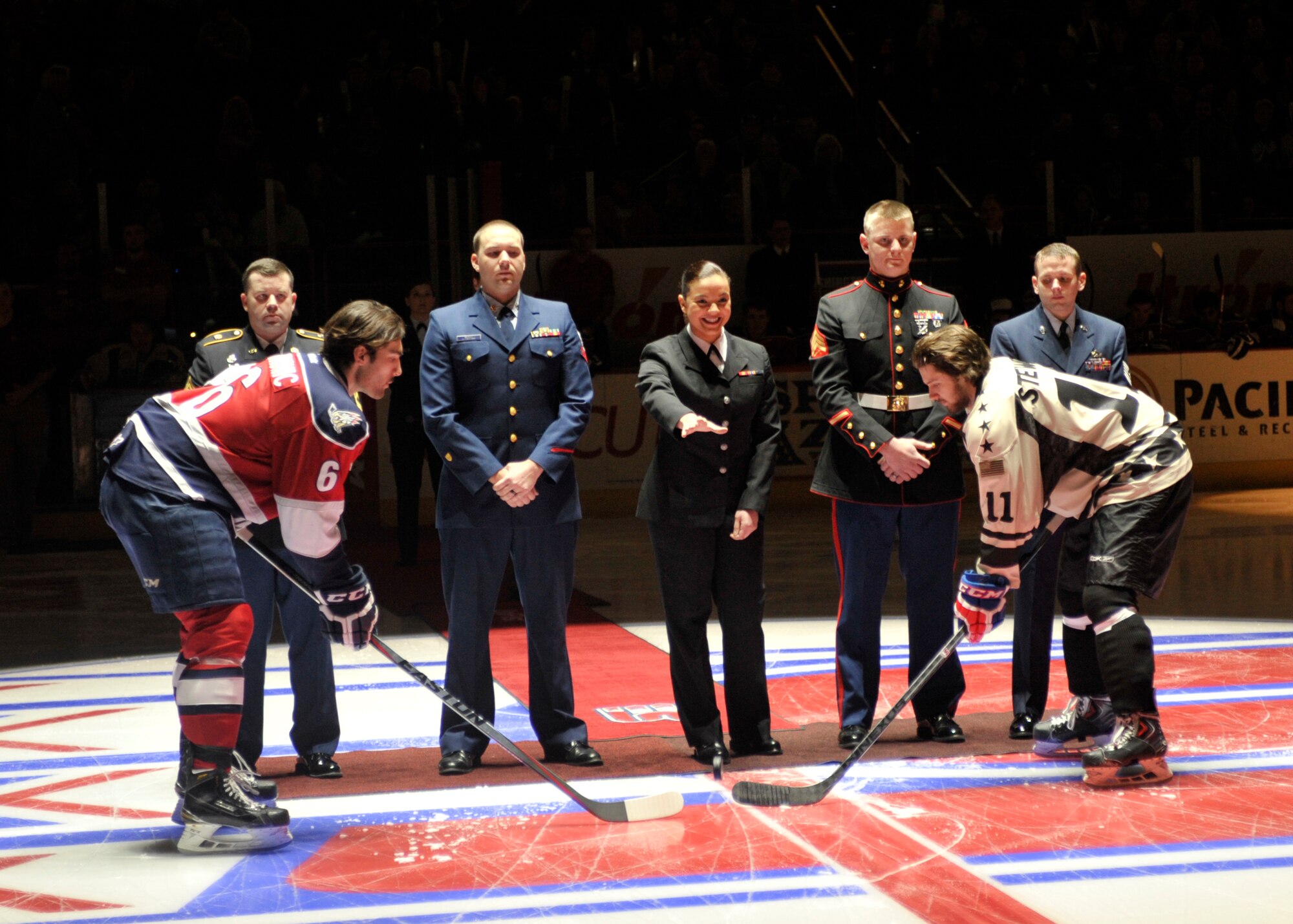 One military member for each branch of the armed forces stands in the middle of the hockey rink as a Sailor ceremoniously drops the puck to start the game between the Spokane Chiefs and the Tri-City Americans Jan. 24, 2015, in Spokane, Wash. The Spokane Chiefs held a Military Appreciation Night and invited all military members from around the county. (U.S. Air Force photo/Airman 1st Class Taylor Bourgeous)