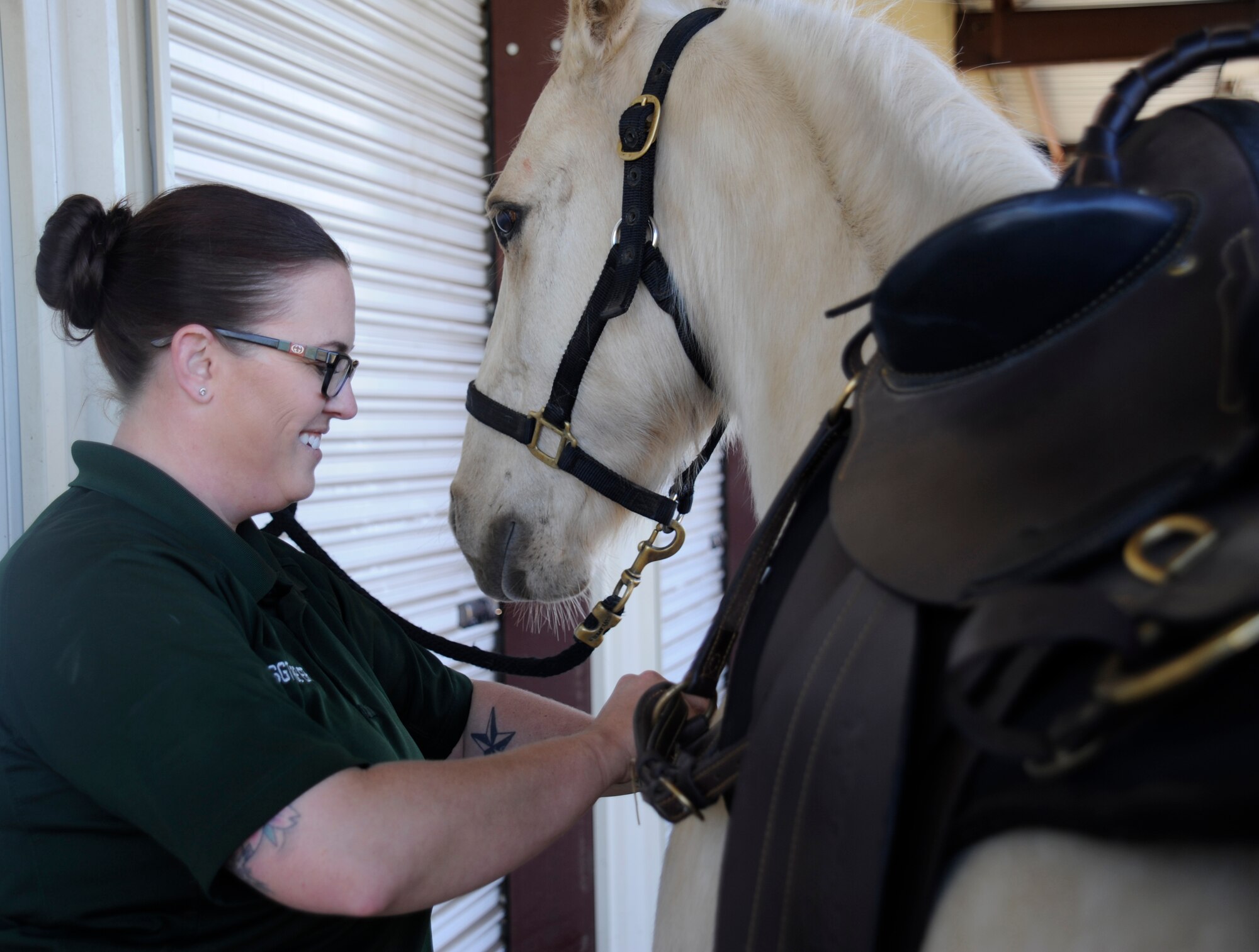 Staff Sgt. Veronica Beyer, 30th Security Forces Squadron horse patrol NCOIC, tightens the saddle on Patton Jan. 14, 2015, Vandenberg Air Force Base, Calif. The 30 SFS horse patrol unit is unique to the Air Force and its members are responsible for the daily care of their team of horses. (U.S. Air Force photo by Airman 1st Class Ian Dudley/Released)