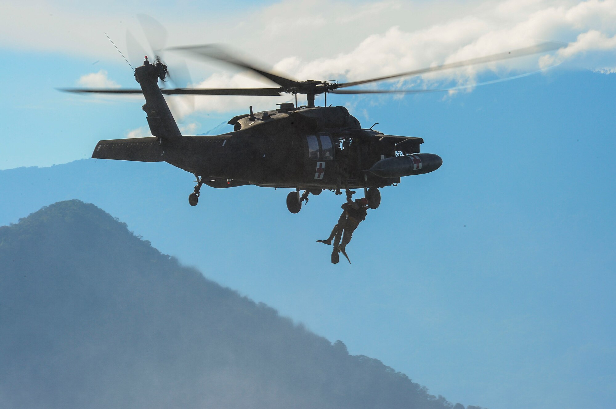 A medic from the 1-228th Aviation Battalion hoists a member of U.S. Army Special Operations Forces into a UH-60 Black Hawk helicopter during over water hoist training at Lake Yojoa, Honduras, Jan. 22, 2015.   The 1-228th Aviation Regiment partnered with U.S. Army Special Operations personnel to practice recovering live personnel. The overwater hoist training was held to ensure members of Joint Task Force-Bravo are planning and preparing for crisis and contingency response, as well as countering transnational organized crime, and counterterrorism operations as part of U.S. Southern Command’s mission. Contingency planning prepares the command for various scenarios that pose the greatest probability of challenging our regional partners or threatening our national interests. (U.S. Air Force photo/Tech. Sgt. Heather Redman)