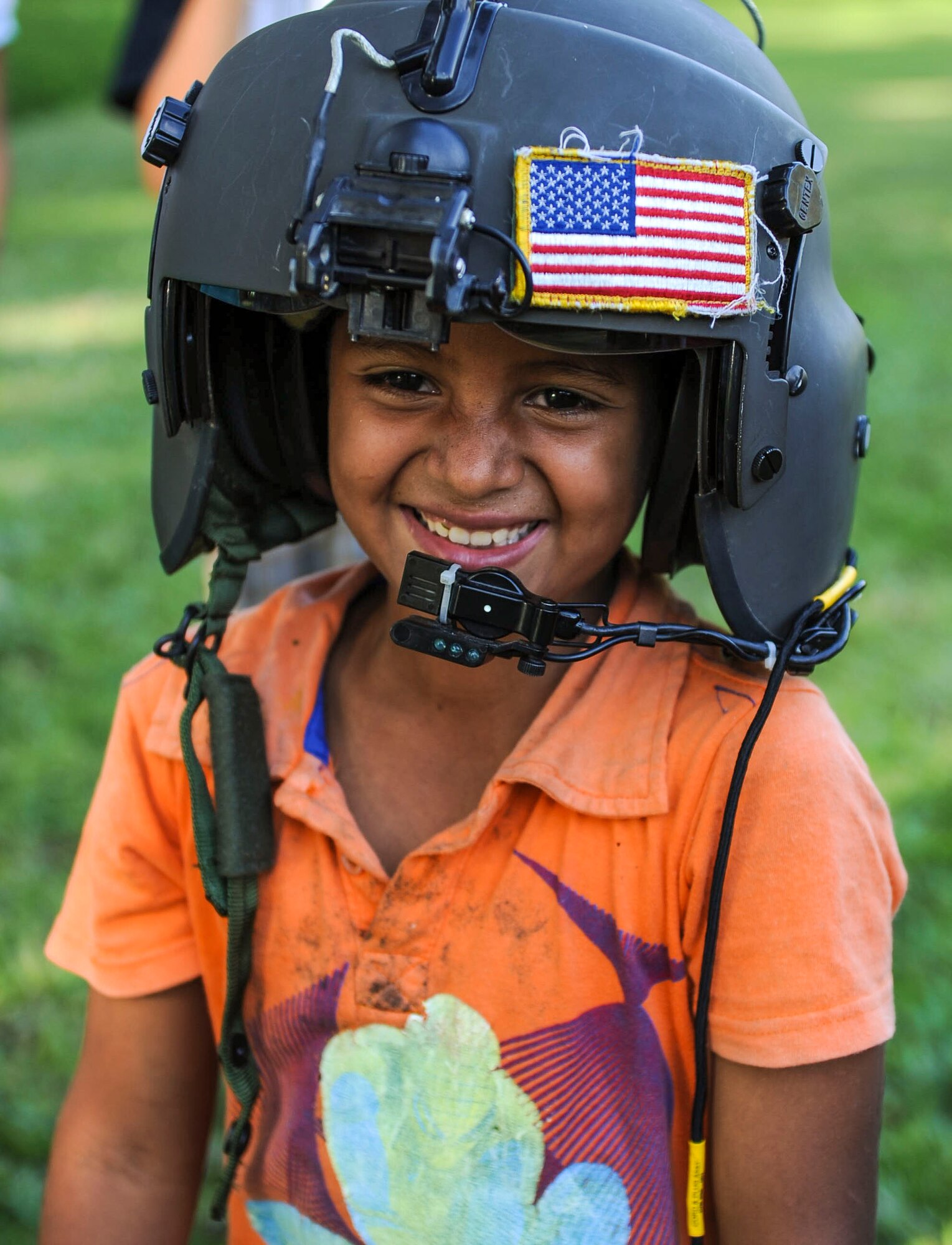 A young boy tries on an aviator helmet at Lake Yojoa, Honduras, Jan. 22, 2015.   The 1-228th Aviation Regiment partnered with U.S. Army Special Operations personnel to practice recovering live personnel. The over-water hoist training was held to ensure members of Joint Task Force-Bravo are planning and preparing for crisis and contingency response, as well as countering transnational organized crime, and counterterrorism operations as part of U.S. Southern Command’s mission. Contingency planning prepares the command for various scenarios that pose the greatest probability of challenging our regional partners or threatening our national interests. (U.S. Air Force photo/Tech. Sgt. Keola Soon)