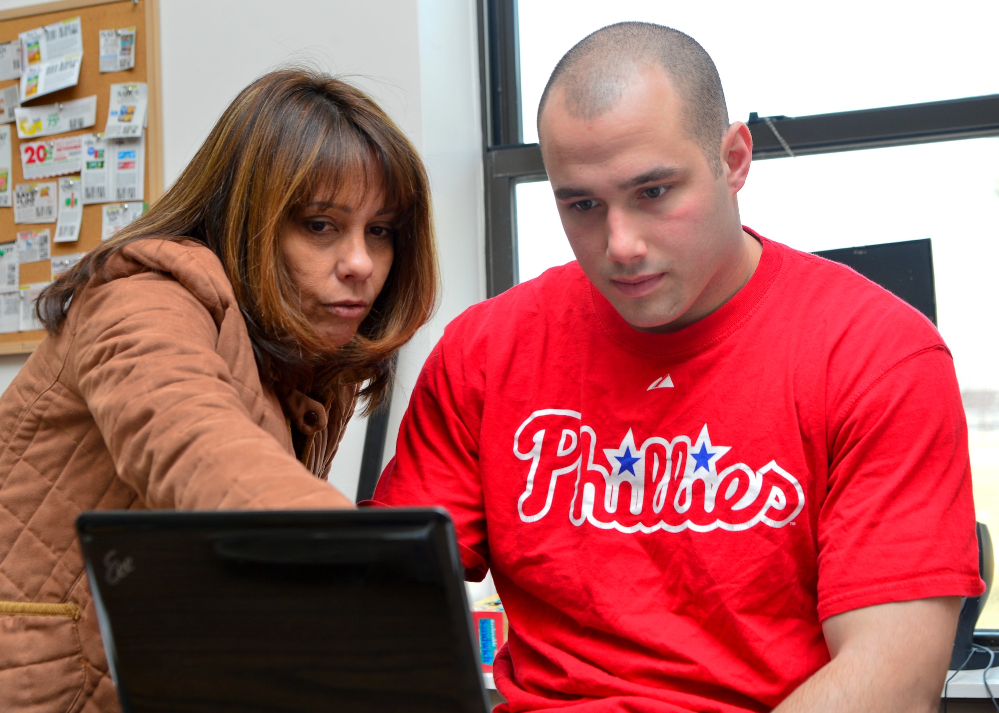 Kathy McNulty, Airman’s Attic volunteer, trains Airman 1st Class Shane Nowrey, 3d Airlift Squadron loadmaster, on data entry logging Jan. 23, 2015, at the Airman’s Attic on Dover Air Force Base, Del. There are 12 shifts a month that Airmen can volunteer for and include work such as signing in customers, inspecting, sorting and displaying donated items and rearranging and loading furniture. (U.S. Air Force photo/Airman 1st Class William Johnson)