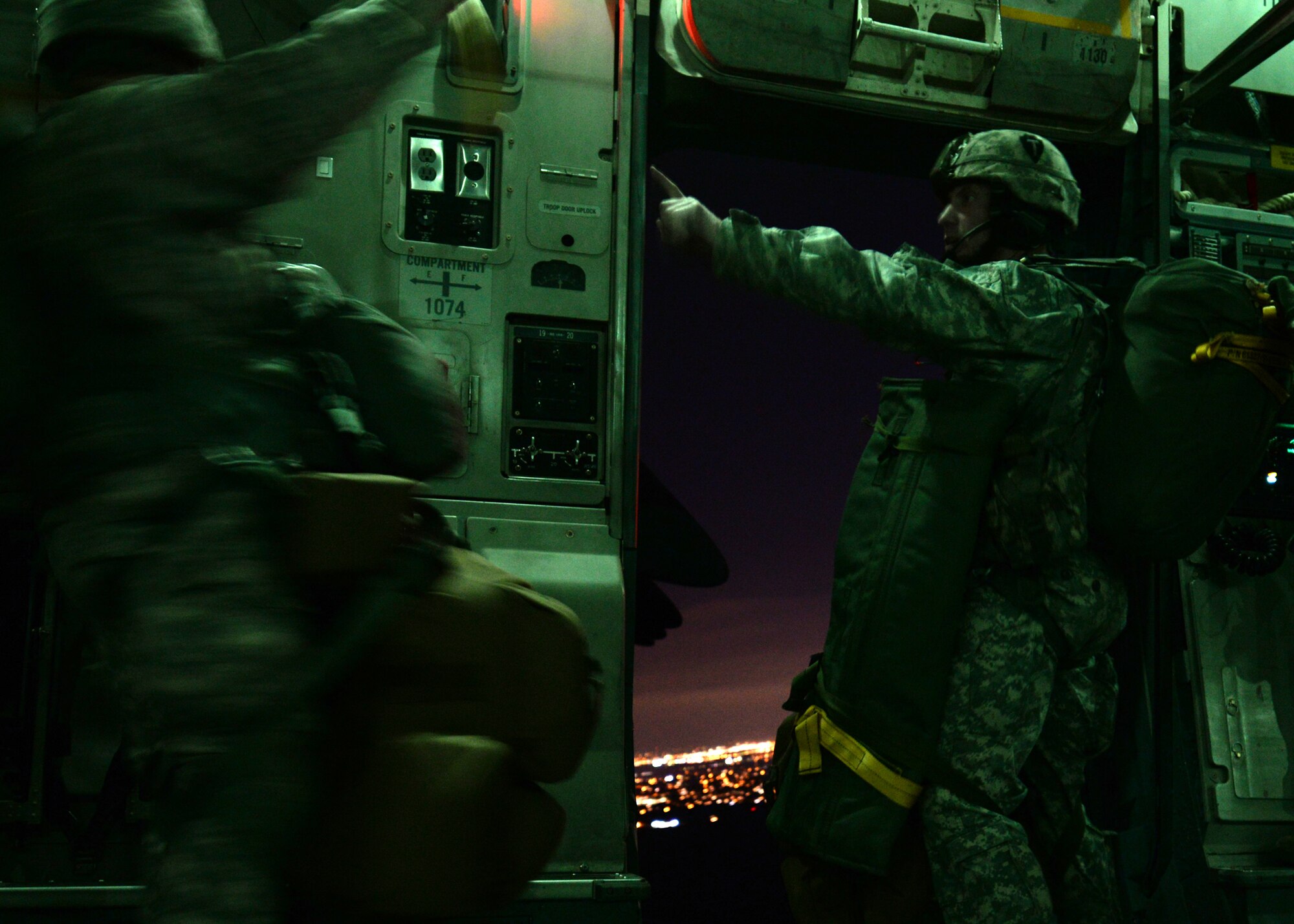 ALTUS AIR FORCE BASE, Okla. – A Texas Army National Guard jumpmaster from the 1st Battalion, 143rd Infantry Regiment signals to other paratroopers that the dropzone is one minute away, near San Antonio, Texas, Jan 23, 2015. Two U.S. Air Force C-17 Globemaster III cargo aircraft dropped approximately 160 National Guard paratroopers from 1,000 feet above the dropzone. (U.S. Air Force photo by Airman 1st Class Nathan Clark/Released)
