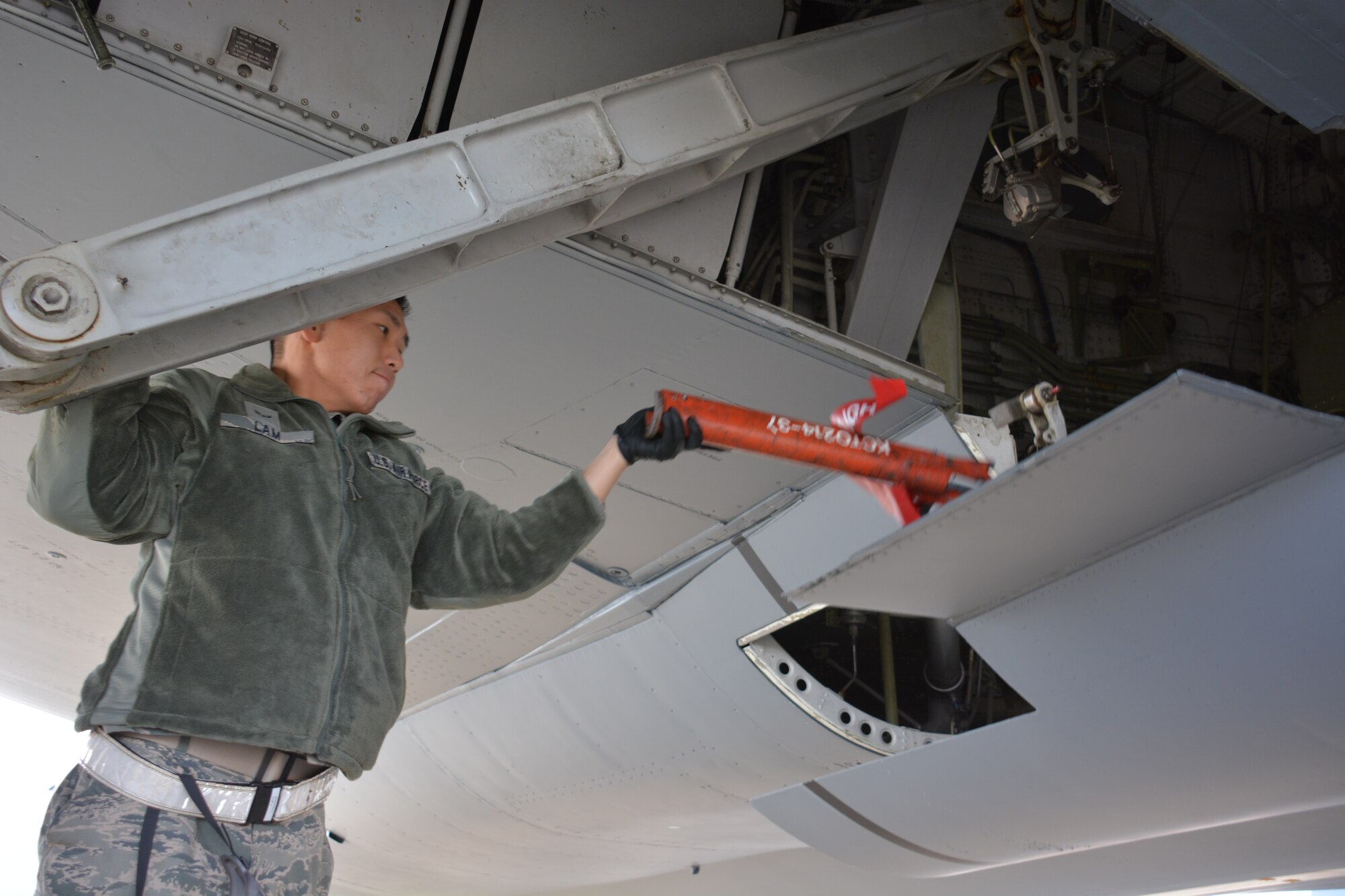 Airman 1st Class Eric Lam, 373rd Training Squadron crew chief student, manually opens the door the left main landing gear of a KC-10 Extender Jan. 21 at Travis Air Force Base, California. (U.S. Air Force photo/Staff Sgt. Christopher Carranza)