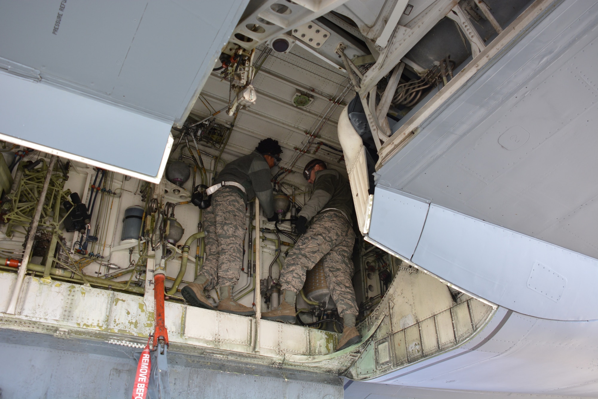 Airmen 1st Class Janiece Ward and Andrew Mantle, 373rd Training Squadron crew chief students, train on the left main land gear accumulator Jan. 21 on the flightline at Travis Air Force Base, California. (U.S. Air Force photo/Staff Sgt. Christopher Carranza)
