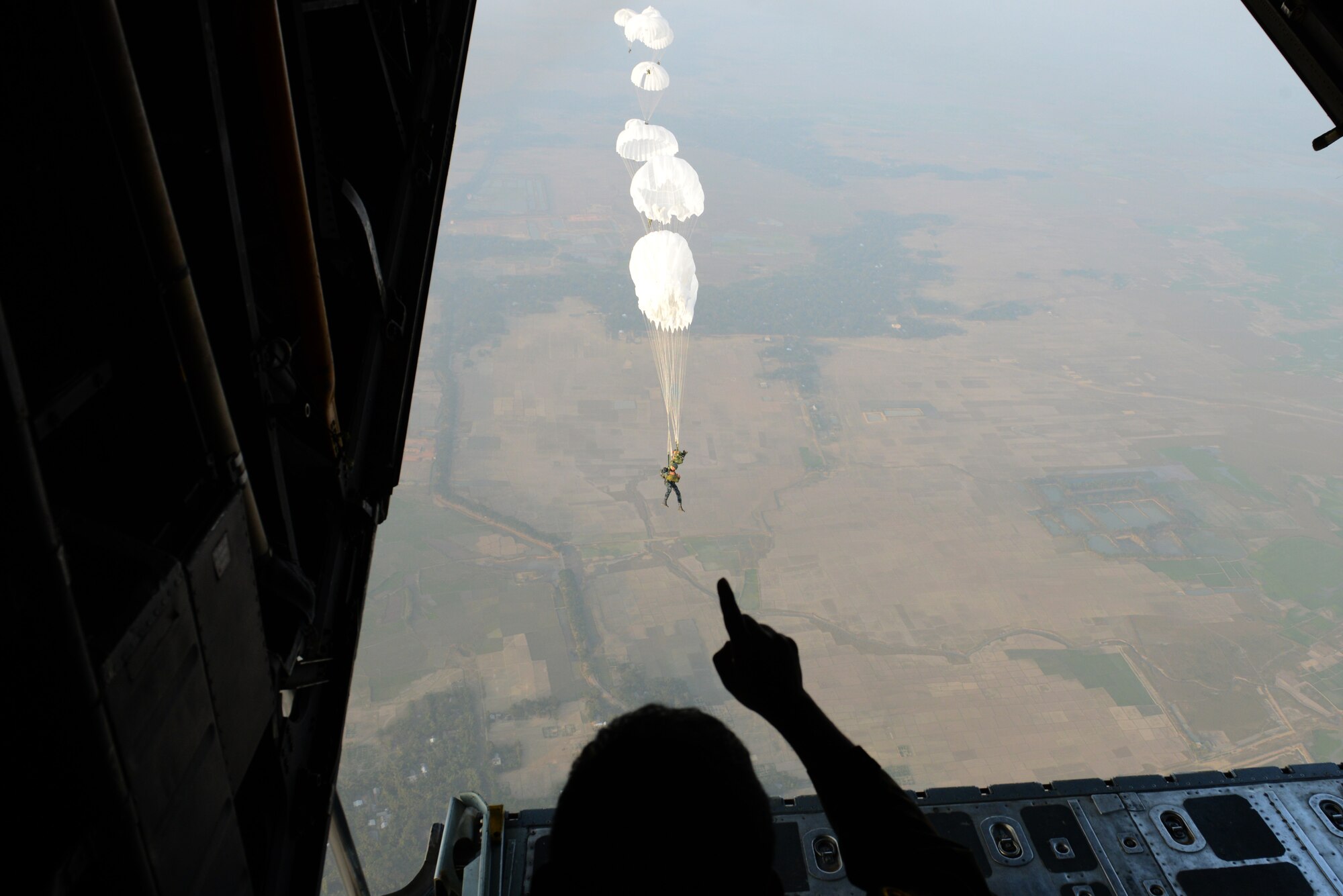 Bangladeshi commandos jump from a U.S. Air Force C-130H aircraft over a drop zone during Exercise COPE SOUTH near Sylhet, Bangladesh, Jan. 24, 2015. COPE SOUTH is a Pacific Air Forces-sponsored, bilateral tactical airlift exercise conducted in Bangladesh, with a focus on cooperative flight operations, day and night low-level navigation, tactical airdrop, and air-land missions as well as subject-matter expert exchanges in the fields of operations, maintenance and rigging disciplines. (U.S. Air Force photo by 1st Lt. Jake Bailey/Released)