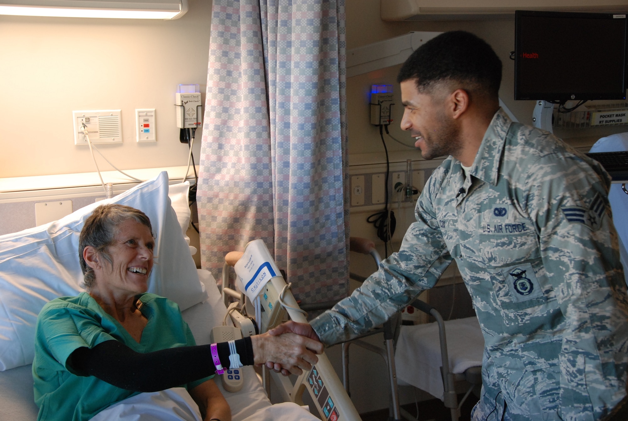 COLORADO SPRINGS, Colo. -- Ali Watts and Senior Airman Elliott Cox, 721st Security Forces Squadron, happily greet each other Jan. 15 at Memorial Hospital. On Jan. 2 Cox responded to Watts’ cries for help after she broke her femur in a skiing accident at Monarch Mountain ski area. Because of his Air Force training, Cox was able to provide first aid, and comfort and stabilize Watts until medical help arrived. Watts had to be airlifted from the scene for medical treatment. (U.S. Air Force photo by Dave Smith)