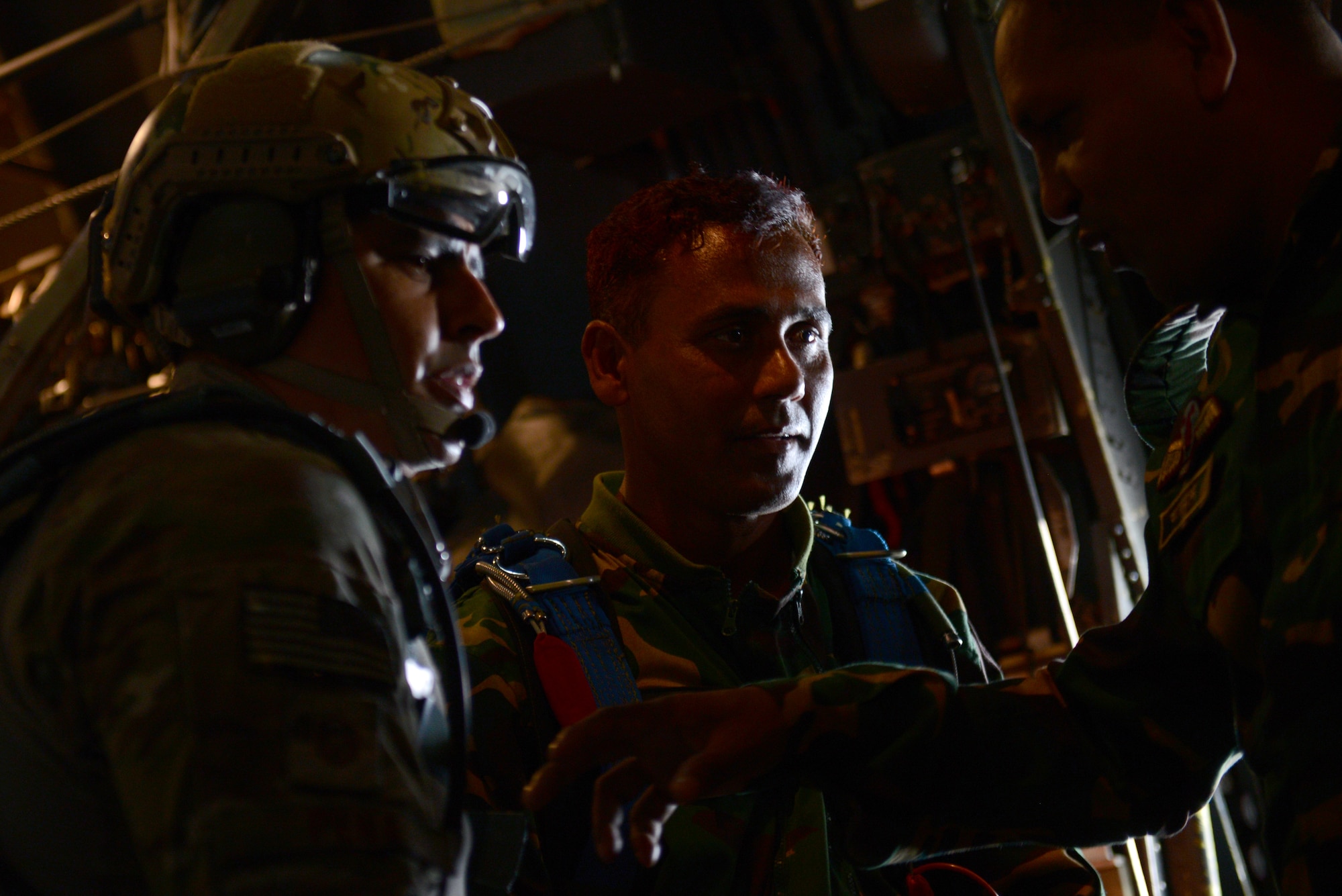 U.S. Air Force Master Sgt. Bobby Pena, a Tactical Air Control Party member assigned to the 3rd Air Support Operations Squadron, Joint Base Elmendorf Richardson, Alaska, confers with Bangladeshi jumpmasters during a personnel airdrop mission at Exercise COPE SOUTH near Sylhet, Bangladesh, Jan. 24, 2015. COPE SOUTH is a Pacific Air Forces-sponsored, bilateral tactical airlift exercise conducted in Bangladesh, with a focus on cooperative flight operations, day and night low-level navigation, tactical airdrop, and air-land missions as well as subject-matter expert exchanges in the fields of operations, maintenance and rigging disciplines. (U.S. Air Force photo by 1st Lt. Jake Bailey/Released)