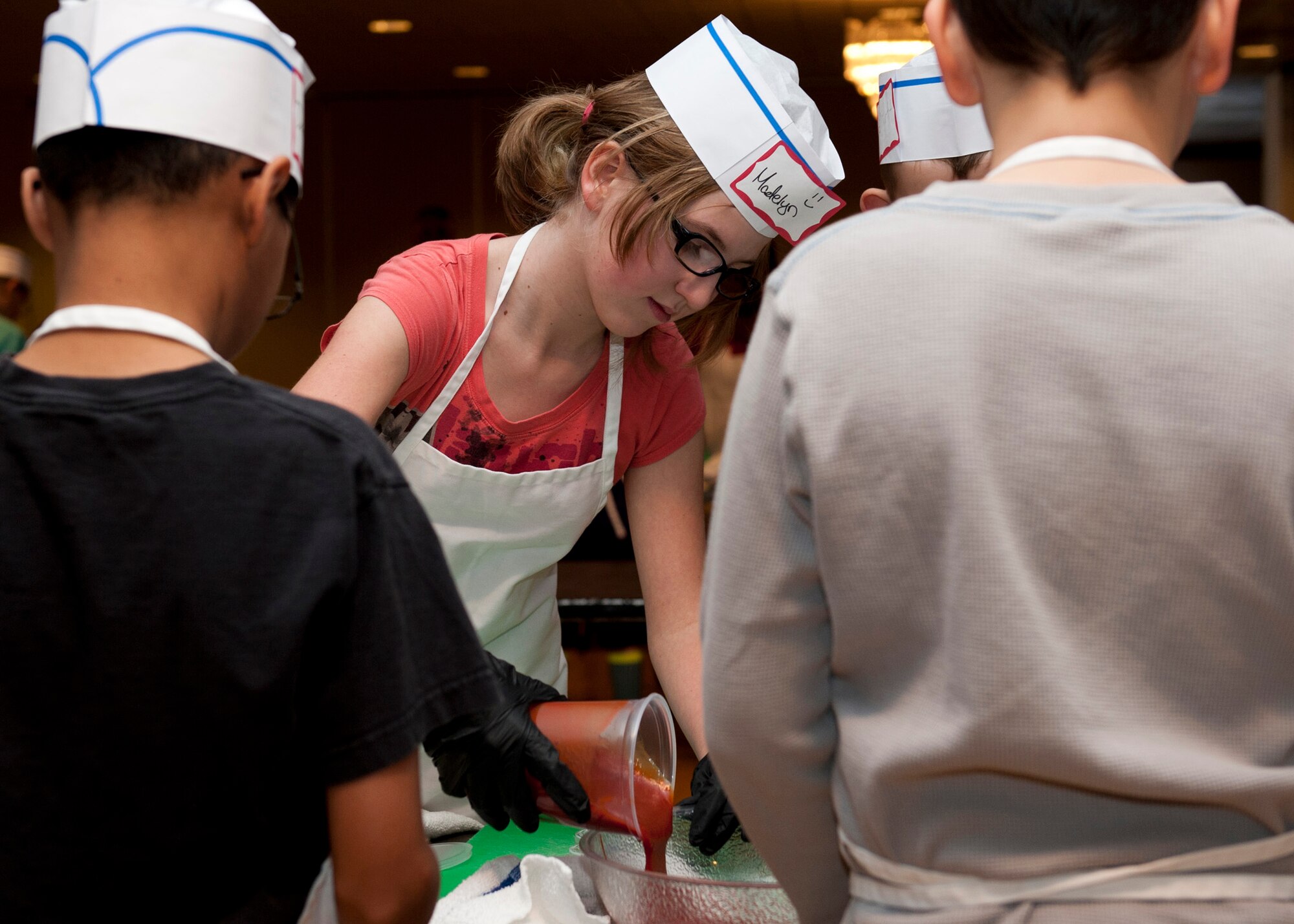 PETERSON AIR FORCE BASE, Colo. – Madelyn Reynolds, daughter of Jess Reynolds, pours ketchup in a bowl to make homemade barbeque sauce during the Kids Barbecue Cooking Camp at The Club, Jan. 17, 2015. Taught by Club chefs Joe Zamora and Kirk Dunning, the kids learned barbecue and grill techniques along with how to prepare a full meal including chicken kabobs, tilapia, homemade barbecue sauce, salad and a desert. (U.S. Air Force photo by Senior Airman Tiffany DeNault)
