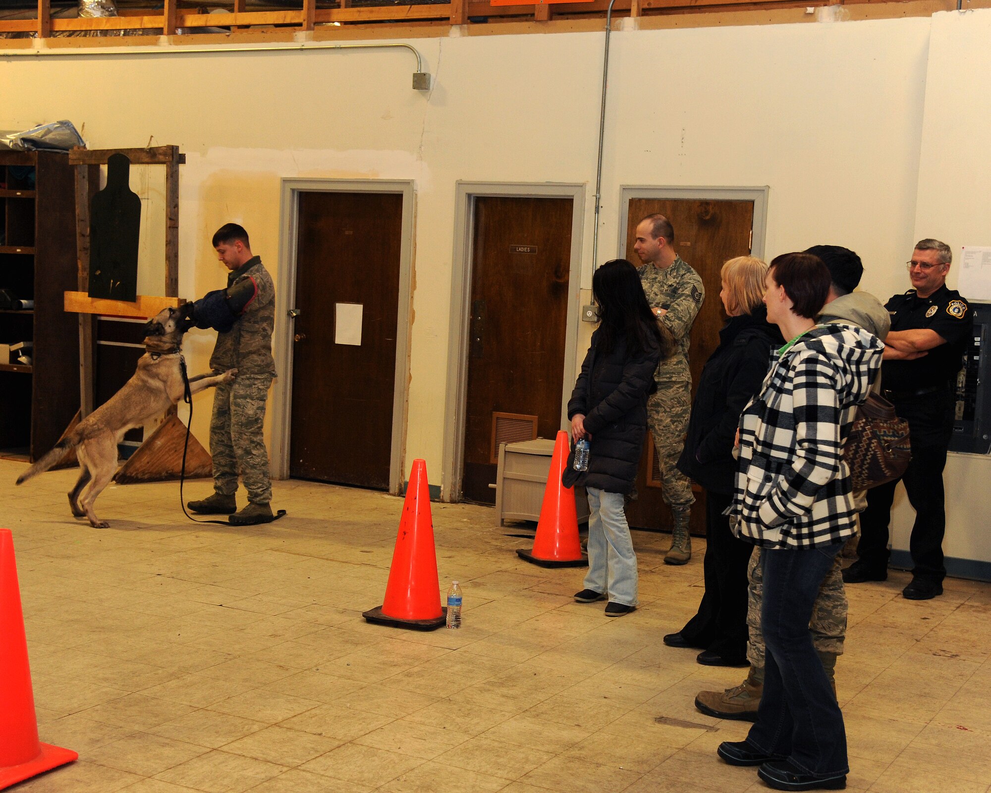 Staff Sgt. Brett Silmon, 319th Security Forces Military working dog handler, offers a military working dog demonstration to a spouses’ group Jan. 22, 2015, on Grand Forks Air Force Base, N.D. The event was part of a new tour program geared toward showing spouses the workplaces of a military base and what each section does. Not only does the group tour the base, but they also attend several briefings including SAPR (sexual assault prevention and response) and resiliency training. “The spouses of our active duty members are the heart and soul of the Air Force. They are the ones who hold down the fort at home. This tour was about them and showing them how they fit into the big picture,” said Patricia Cerone, 319th Air Base Wing community support coordinator. (U.S. Air Force photo/Senior Airman Zachiah Roberson)