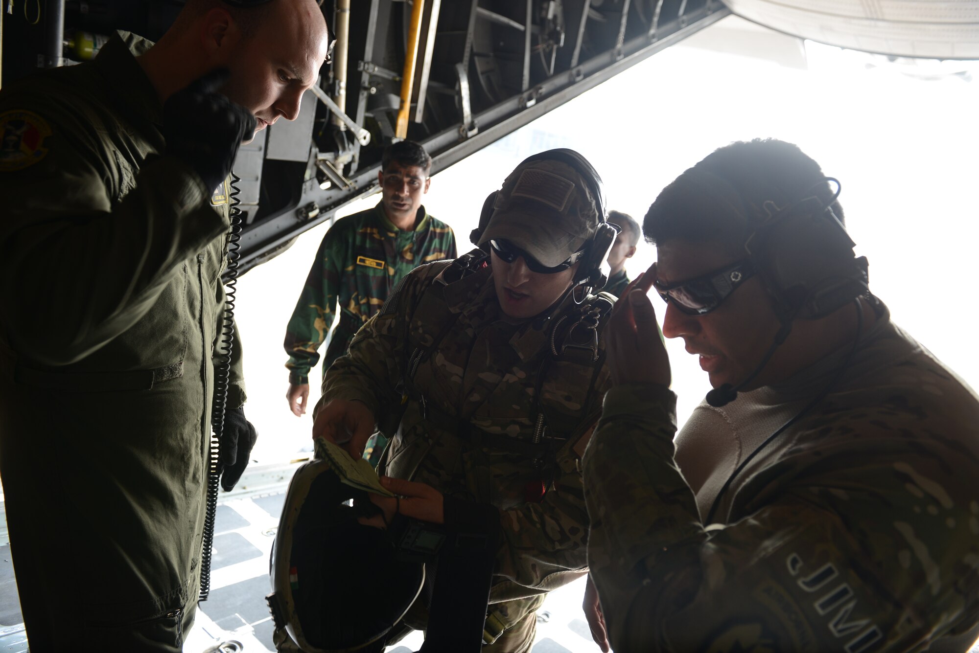 From right to left: Master Sgt. Bobby Pena, Staff Sgt. Ben Johnis and Staff Sgt. Noel Jones review a paratrooper jump plan aboard a C-130H aircraft at Sylhet International Airport, Bangladesh, before conducting a personnel airdrop mission during Exercise COPE SOUTH, Jan. 24, 2015. Pena is a Tactical Air Control Party member assigned to the 3rd Air Support Operations Squadron, Joint Base Elmendorf Richardson, Alaska; Johnis is a S.E.R.E. instructor assigned to the 374th Operations Support Squadron, Yokota Air Base, Japan; and Jones is a loadmaster assigned to the 36th Airlift Squadron at Yokota. U.S. Air Force COPE SOUTH is a Pacific Air Forces-sponsored, bilateral tactical airlift exercise conducted in Bangladesh, with a focus on cooperative flight operations, day and night low-level navigation, tactical airdrop, and air-land missions as well as subject-matter expert exchanges in the fields of operations, maintenance and rigging disciplines. COPE SOUTH helps cultivate common bonds, foster goodwill, and improve readiness and compatibility between members of the Bangladesh and U.S. Air Forces. (U.S. Air Force photo by 1st Lt. Jake Bailey/Released)