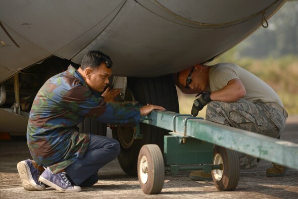 Bangladesh air force Warrant Officer Taibur, left, and U.S. Air Force Staff Sgt. Anthony Polio attach a tow bar to a USAF C-130H aircraft during Exercise COPE SOUTH 15 at BAF Base Bangabandhu, Bangladesh, Jan. 23, 2015. Polio is a C-130H flying crew chief assigned to the 374th Aircraft Maintenance Squadron at Yokota Air Base, Japan.  COPE SOUTH helps cultivate common bonds, foster goodwill, and improve readiness and compatibility between members of the Bangladesh and U.S. Air Forces. (U.S. Air Force photo by 1st Lt. Jake Bailey/Released)