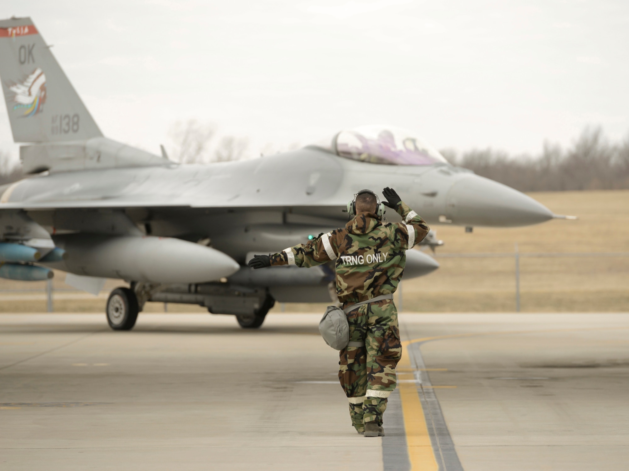 A crew chief, assigned to the 138th Maintenance Group, marshals an F-16 into its parking position during an operational readiness exercise (ORE) held, Jan. 10, 2015, at the Tulsa Air National Guard Base, Okla. The 138th Fighter Wing conducted the ORE to assess the 138th Fighter Wing's ability to accomplish design operational capability tasking in a contested, degraded operational environment utilizing ability to survive and operate principles.  (U.S. National Guard photo by Master Sgt.  Mark A. Moore/Released)