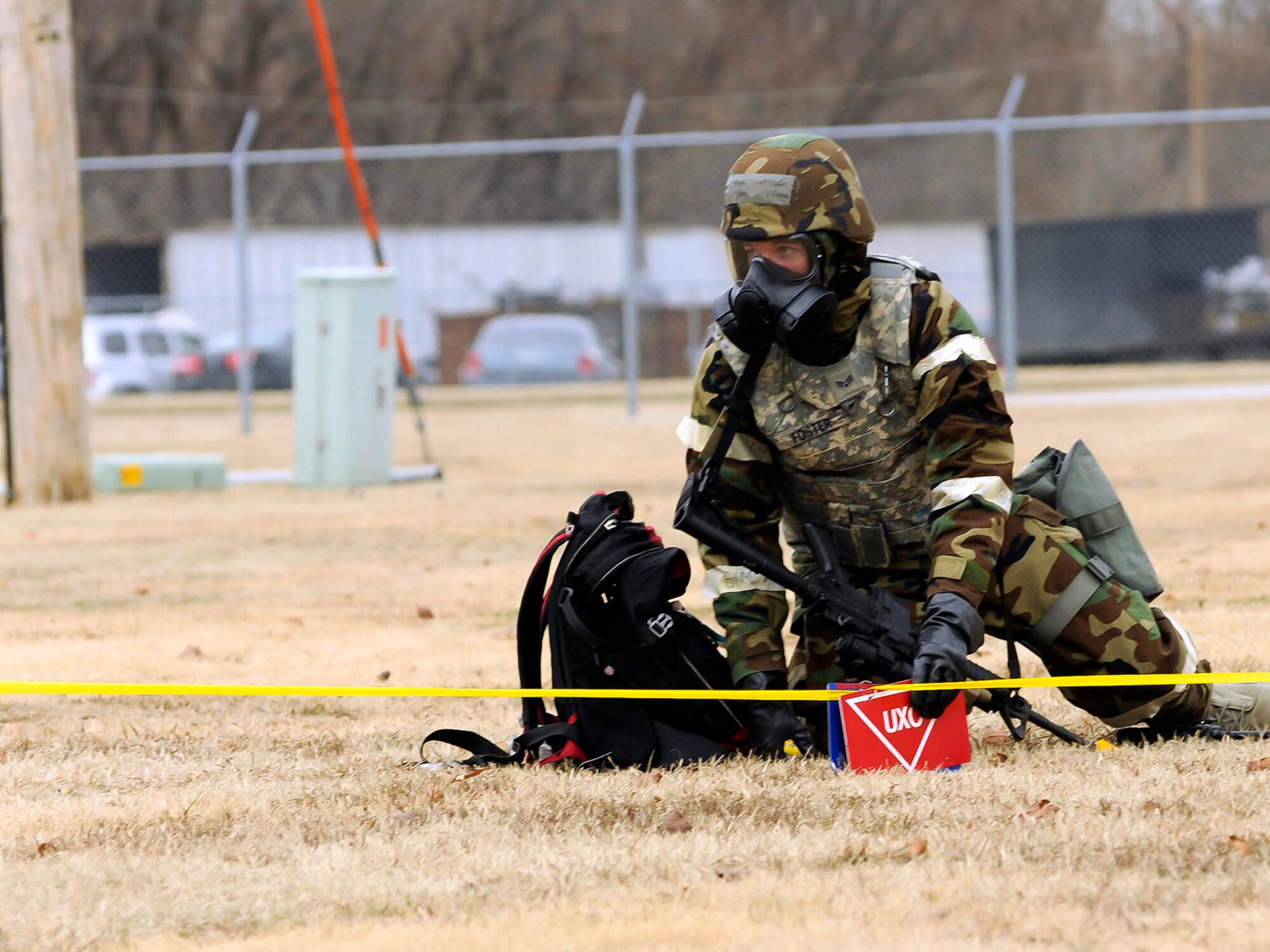 Senior Airman David Foster, 138th Security Forces, places a marker while cordoning off an unexploded ordinance found while conducting a post attack reconnaissance during a wing exercise on January 10, 2015, at the 138th Fighter Wing.  Tulsa Air National Guard members participated in refresher force protection training to reinforce chemical, biological and self-buddy aid practices.  (U.S. National Guard photo by Tech. Sgt. Roberta A. Thompson/Released)