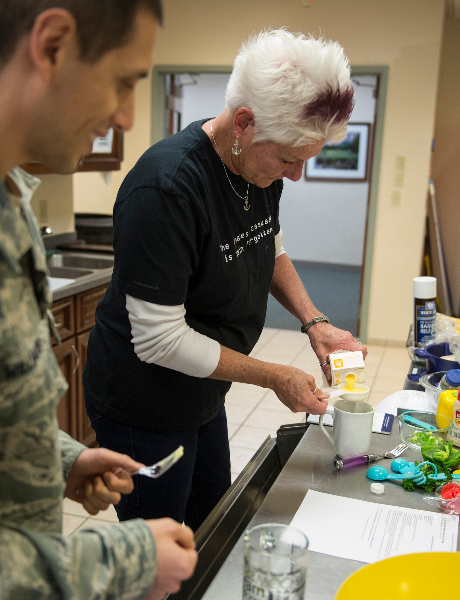 Dawn Nickerson-Banez, local bakery owner and honorary commander, measures egg mixture for quiche in a mug Jan. 21, 2015, during a microwave cooking class for service members assigned to Air Force Mortuary Affairs Operations, Dover Air Force Base, Del. The class demonstrated the healthy cooking options while living in a dorm or lodging environment. (U.S. Air Force photo by Staff Sgt. John E. Ayre)