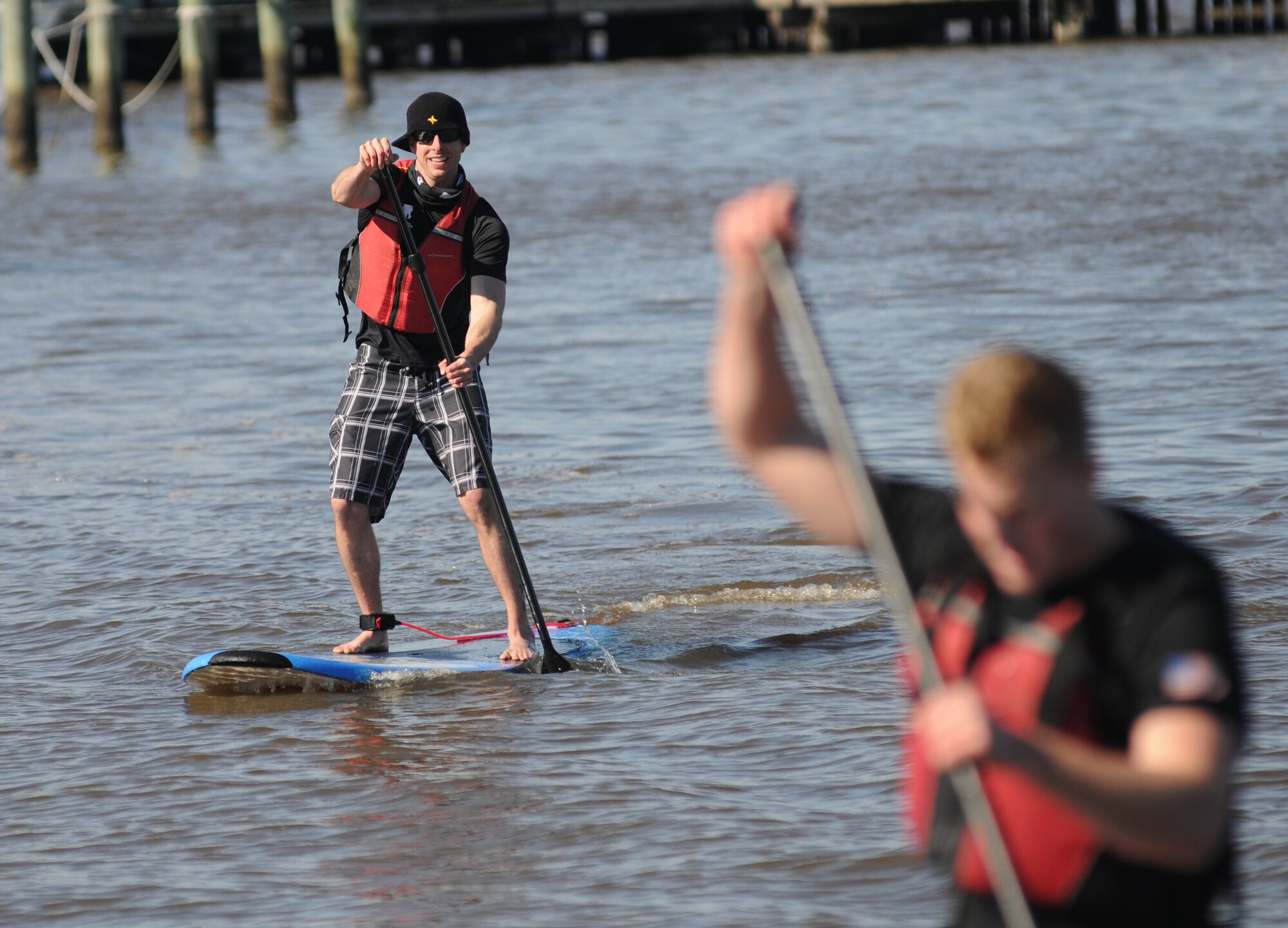 Staff Sgt. Jason Jones, noncommissioned officer in charge of 81st Medical Support Squadron information systems, closes in on Second Lt. Daniel Baucke, 333rd Training Squadron cyber warfare operations student, in the paddle board race during the third annual Polar Bear Regatta Jan. 24, 2015, at marina park, Keesler Air Force Base, Miss.  The event was sponsored by outdoor recreation. (U.S. Air Force photo by Kemberly Groue)