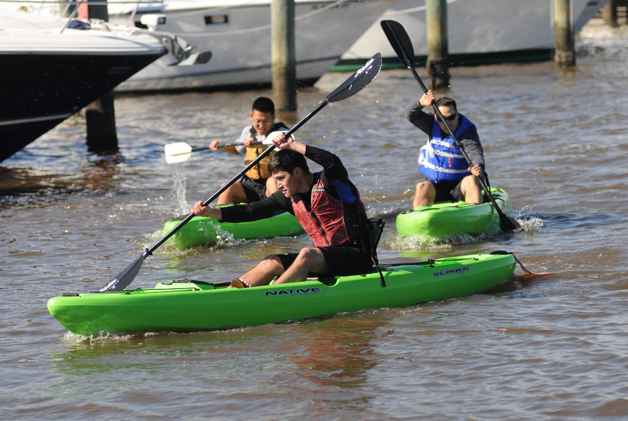 Second Lt. Jonathan Eng steers his kayak through the Keesler Marina as he is followed closely by 2nd Lt. Kyung Kim and Staff Sgt. Grant Coomes in the kayak races during the  third annual Polar Bear Regatta Jan. 24, 2015, at marina park, Keesler Air Force Base, Miss.  Eng and Kim are students and Coomes is an instructor in the 333rd Training Squadron cyber warfare operations course.  The event was sponsored by outdoor recreation. (U.S. Air Force photo by Kemberly Groue)