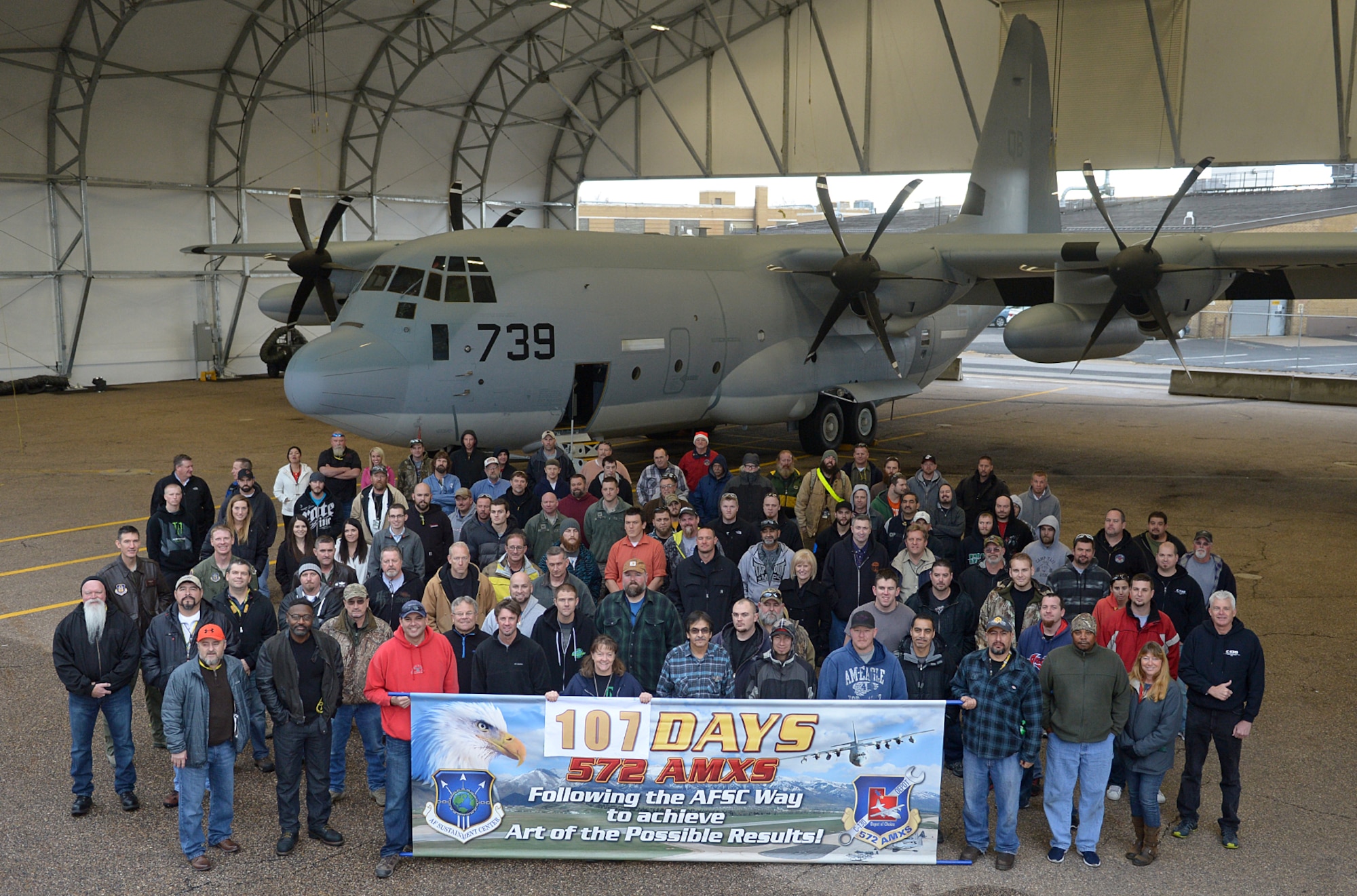 Members of the 572nd Maintenance Squadron at Hill Air Force Base, Utah, pose with a sign commemorating their record-breaking performance. The squadron used the Air Force Sustainment Center Way process to reduce the number of "flow days" of depot maintenance from 117 to 107. (Air Force photo by Alex R. Lloyd)