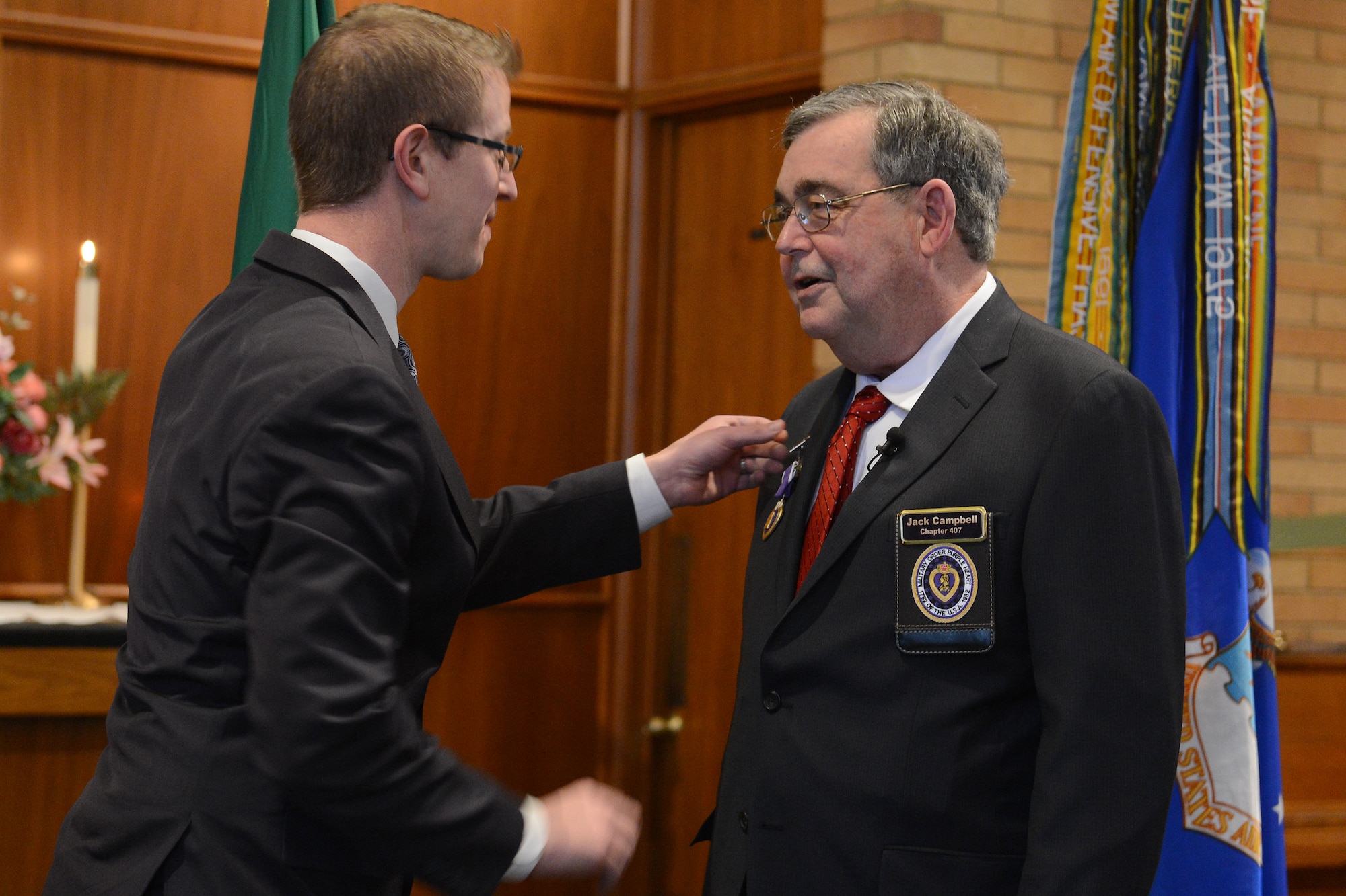 Congressman Derek Kilmer, 6th District of Washington, presents Staff Sgt. John Campbell, Air Force veteran, with the Purple Heart Jan. 25, 2015 at American Lake Chapel, Tacoma, Wash.  Campbell was wounded Jan. 1, 1970, during an enemy attack while he was stationed in Laos. Due to the fact that his mission was classified, he was forced to wait for it to become declassified and in 2014 it was and he was awarded his Purple Heart with a back date of Jan. 1, 1970. (U.S. Air Force photo\ Staff Sgt. Tim Chacon)