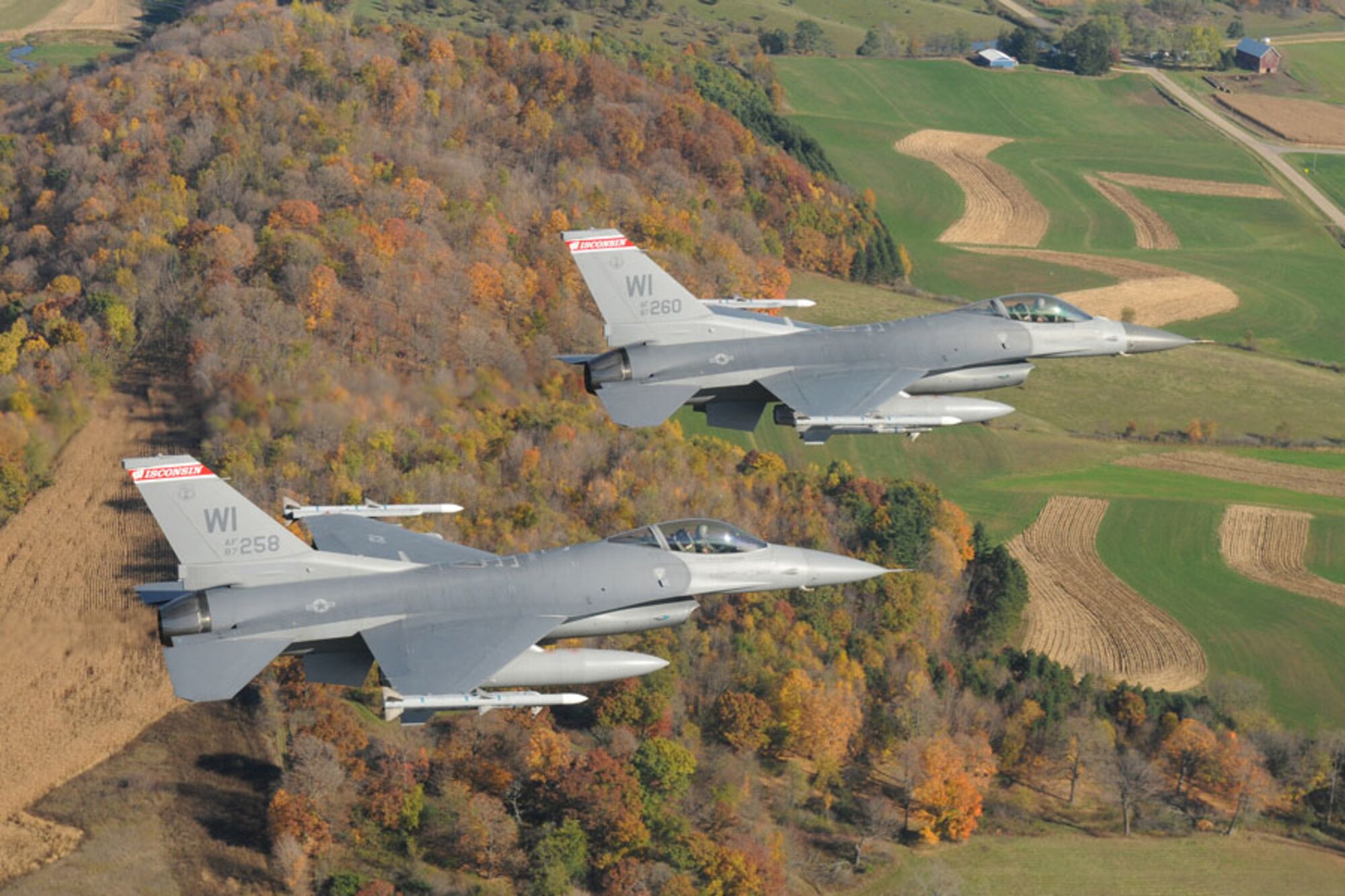 Two F-16C Fighting Falcons from the 115th Fighter Wing, Wisconsin Air
National Guard, fly a routine training mission in the skies over Wisconsin in
2008. A program office at Hanscom AFB, Mass., recently completed fielding of
a system that will provide tactical data link messaging between aircraft
such as these and continental United States air defense sectors to improve
homeland defense. (U.S. Air Force photo by Master Sgt. Paul Gorman)