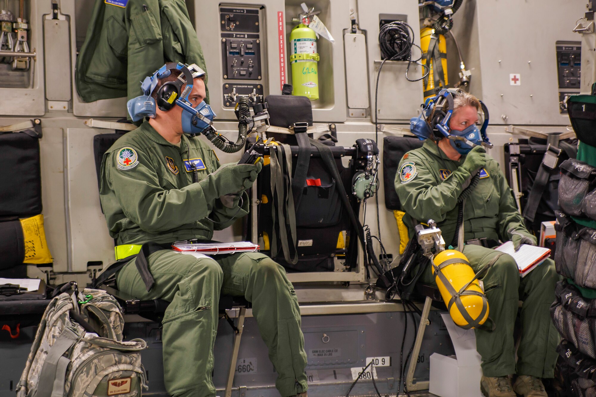 Medical professionals from the Air Force Reserve's 446th Aeromedical Evacuation Squadron here at Joint Base Lewis-McChord, down oxygen masks to simulate aircraft decompression during a training scenario on a McChord Field C-17 Globemaster III aircraft during the unit's in-flight medical training, Jan. 21, 2015. The 2,100 men and women assigned to the 446th AW support the Air Mobility Command (AMC) mission around the world on a daily basis, performing 44 percent of all C-17 missions leaving JBLM. (U.S. Air Force Reserve photo by Jake Chappelle)