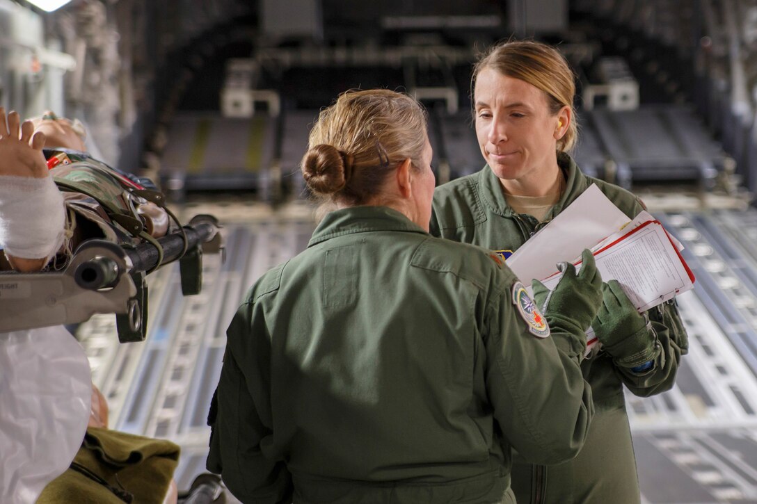 Air Force Reserve Maj. Shana Weber (facing front), and Maj. Beverly Davidson, flight nurses with the 446th Aeromedical Evacuation Squadron here at Joint Base Lewis-McChord, discuss a training scenario on a McChord Field C-17 Globemaster III transport aircraft during the unit's in-flight medical training, Jan. 21, 2015. The 2,100 men and women assigned to the 446th AW support the Air Mobility Command (AMC) mission around the world on a daily basis, performing 44 percent of all C-17 missions leaving JBLM. (U.S. Air Force Reserve photo by Jake Chappelle)