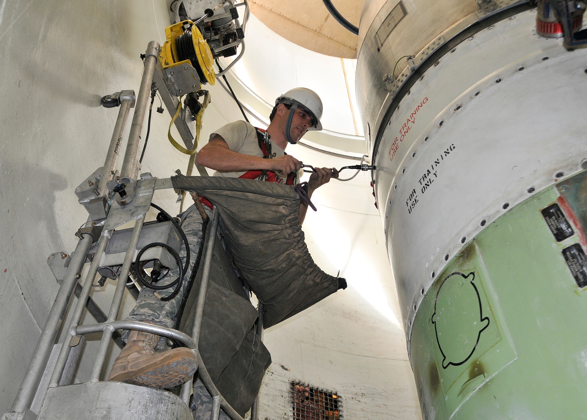Staff Sgt. Isaiah Miller, 341st Missile Maintenance Squadron, uses a guided missile maintenance platform May 7, 2010, to remove bolts securing the reentry system on a mock-up of a Minuteman III missile during a maintenance training exercise at Malmstrom Air Force Base’s T-9 launch facility maintenance trainer. (U.S. Air Force photo/John Turner)