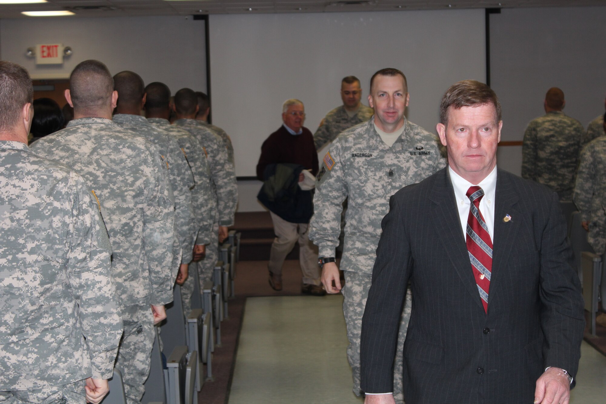 Students stand as Kenneth Preston, former Sgt. Major of the Army, Command Sgt. Major Richard Anderson, Army Support Activity-Dix, and Shane Byrd, Fort Dix NCO Academy commandant, exit the Graduation Hall at the Fort Dix NCOA on Joint Base McGuire-Dix-Lakehurst, N.J., Jan. 9, 2015. (U.S. Army photo by Sgt. 1st Class Aumtep Hill/Released)