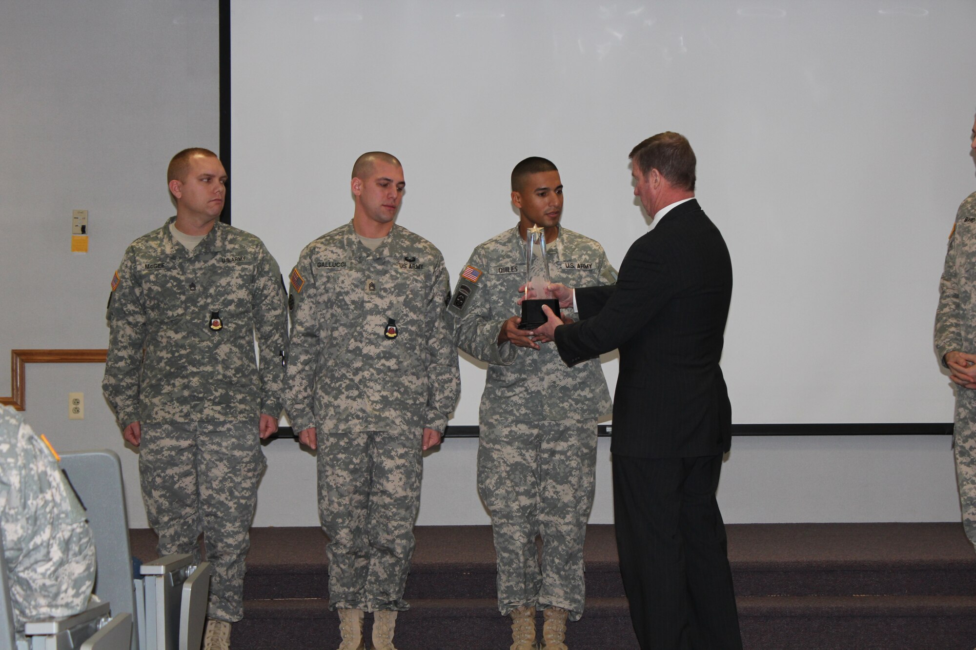 Sgts. 1st Class Jeffery Mcgee and Michael Gallucci and Staff Sgt. Victor Quiles receive a trophy from Kenneth Preston, former Sgt. Major of the Army, at the Fort Dix NCO Academy on Joint Base McGuire-Dix-Lakehurst, N.J., Jan. 9, 2015. (U.S. Army photo by Sgt. 1st Class Aumtep Hill/Released)