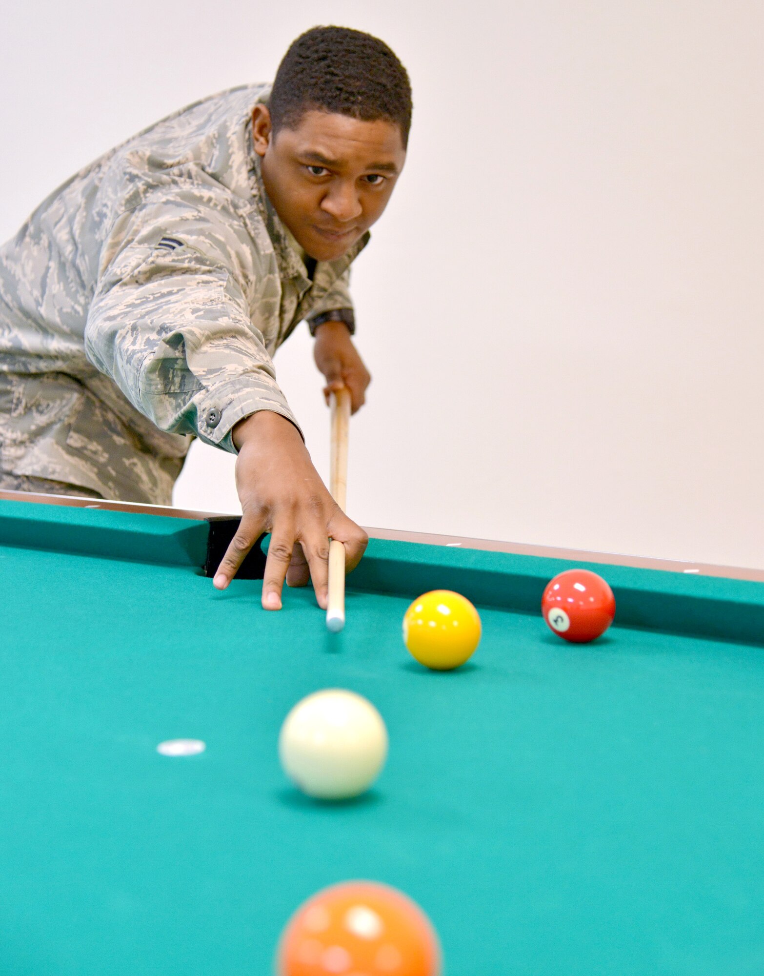 Airman 1st Class Quentin Fields, 58th Operations Support Squadron, shoots pool at the Gravity Airmen Ministry Center. The new facility is stocked with activities to help keep Airmen entertained, such as video gaming, pool, foosball and air hockey. The ribbon cutting for the center, located by the base theater across from the post office, will be Feb. 5. (Photo by Jamie Burnett)